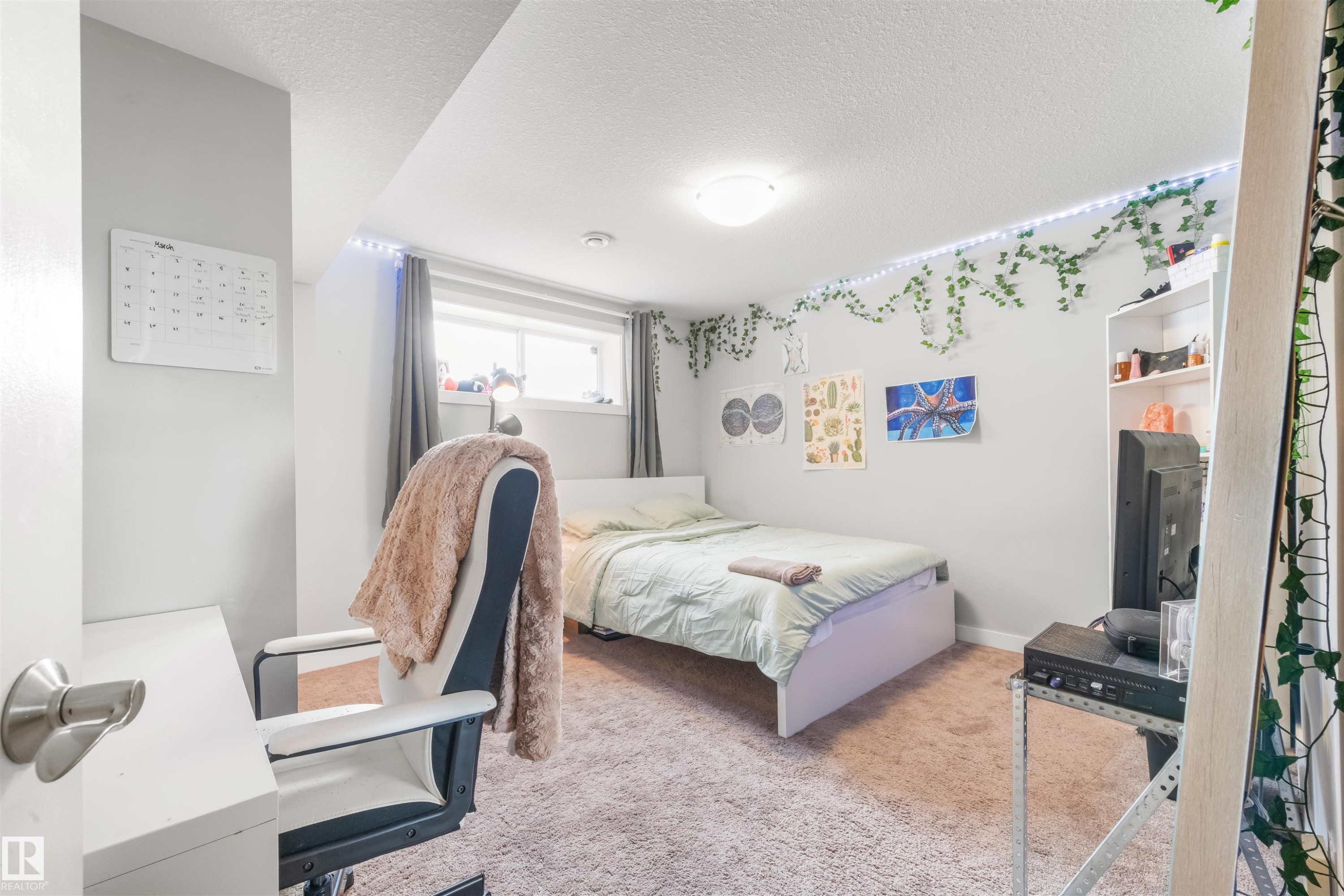 This room features a window providing natural light and light-colored carpeting - 607 40 Street Sw, Edmonton, AB - Indoor Photo Showing Bedroom