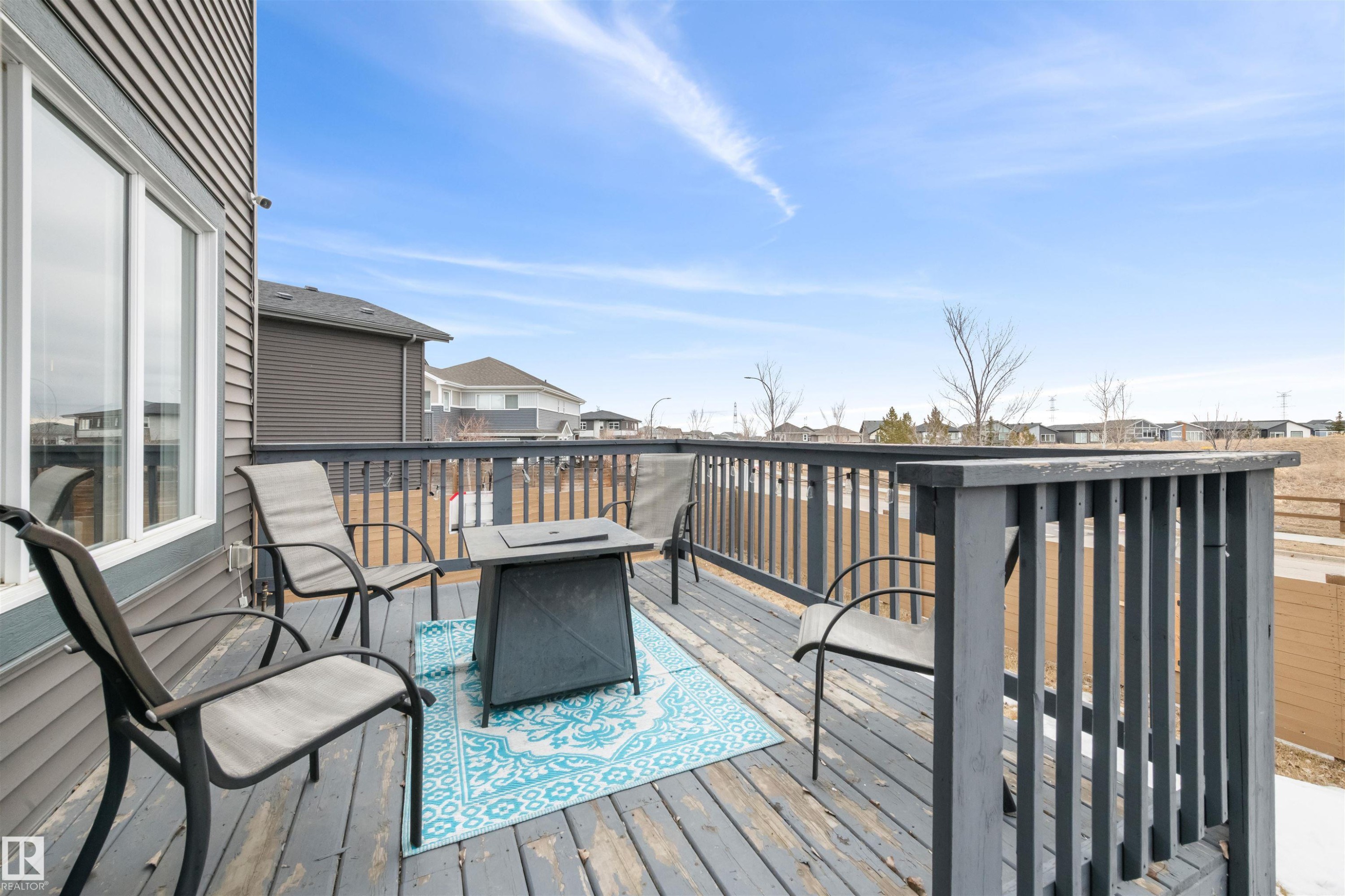 The property features an exterior deck with a wooden railing and grey siding - 607 40 Street Sw, Edmonton, AB - Outdoor With Deck Patio Veranda With Exterior