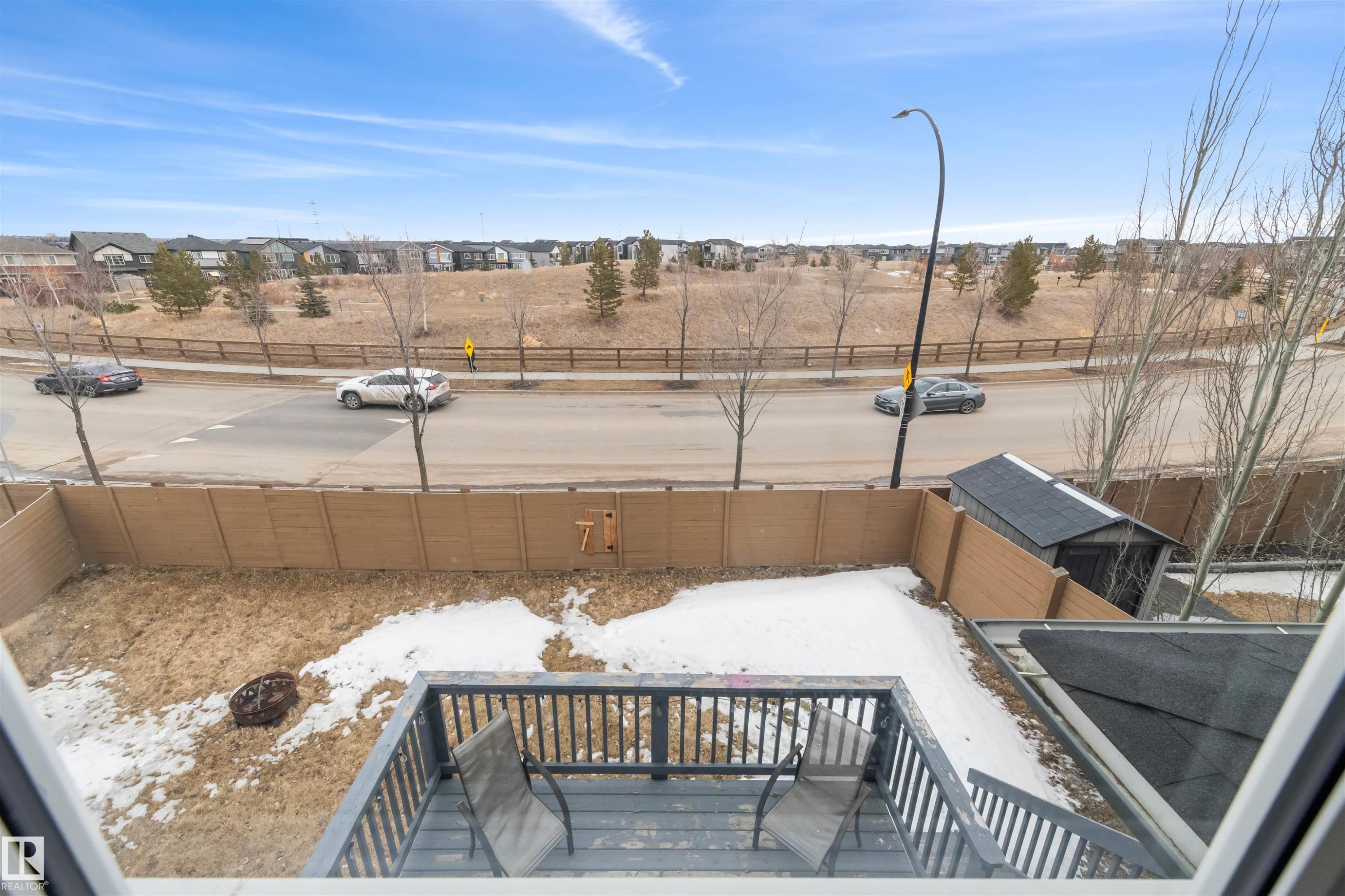 The property features a wooden deck with railing, a storage shed, and a fenced backyard - 607 40 Street Sw, Edmonton, AB - Outdoor