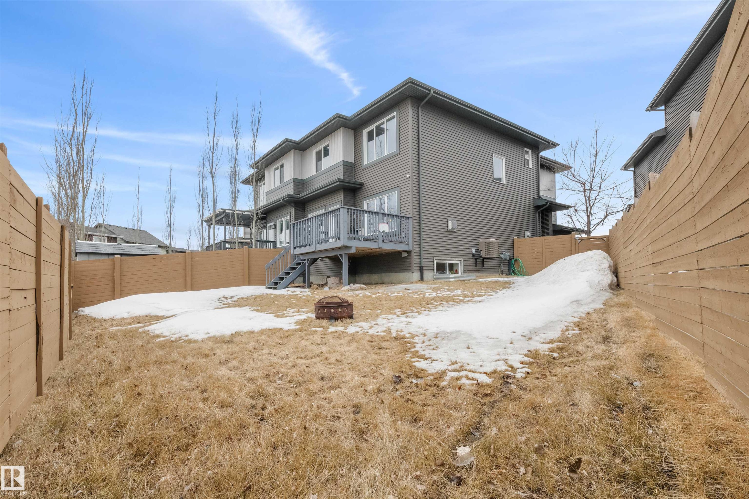 The property features a private backyard with a wooden fence, a deck with stairs, and a fire pit - 607 40 Street Sw, Edmonton, AB - Outdoor With Exterior