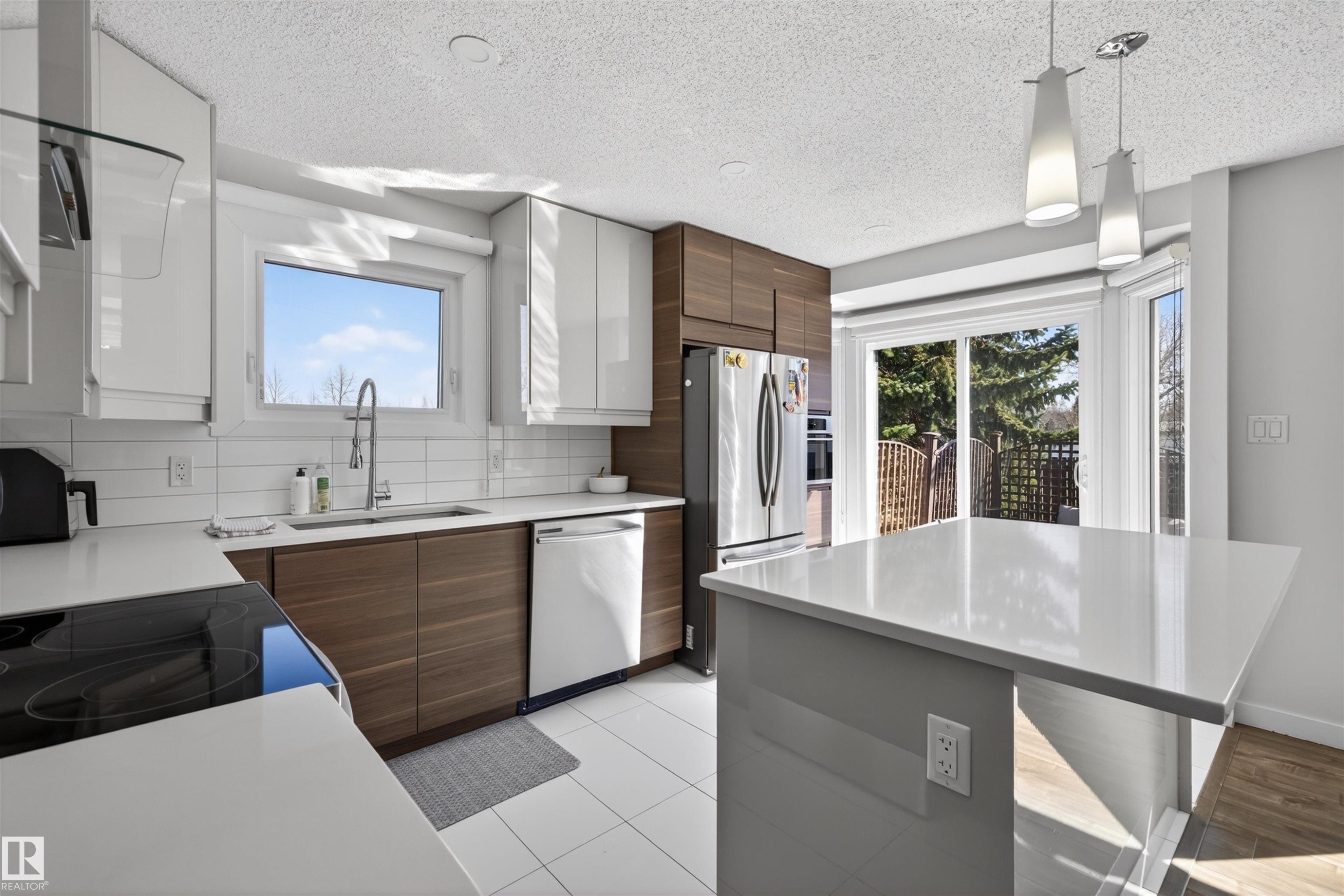Contemporary kitchen featuring white shaker upper cabinetry and wood-finish lower cabinetry - 15251 88A Street, Edmonton, AB - Indoor Photo Showing Kitchen