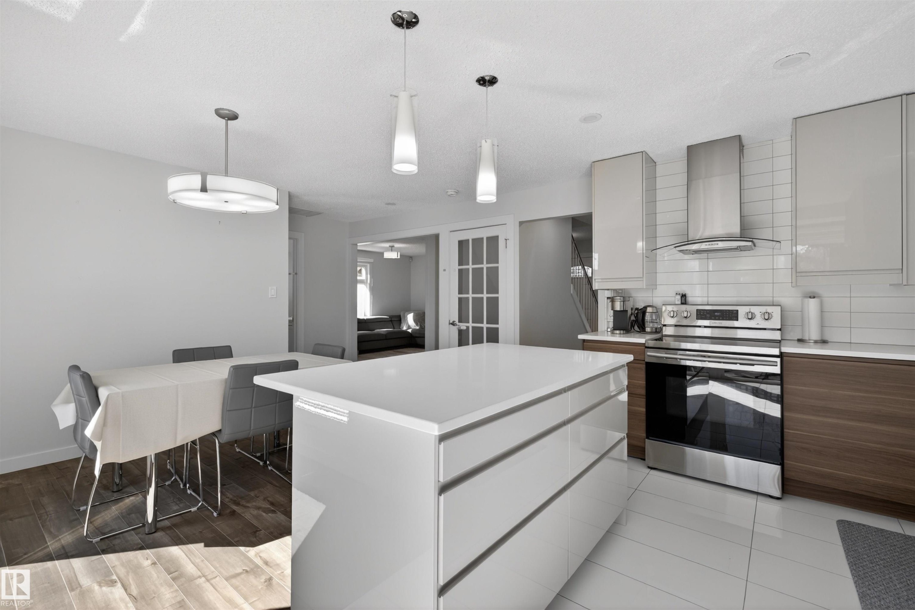 Open-concept kitchen with a large central island, stainless steel appliances, and contrasting cabinetry - 15251 88A Street, Edmonton, AB - Indoor Photo Showing Kitchen With Upgraded Kitchen