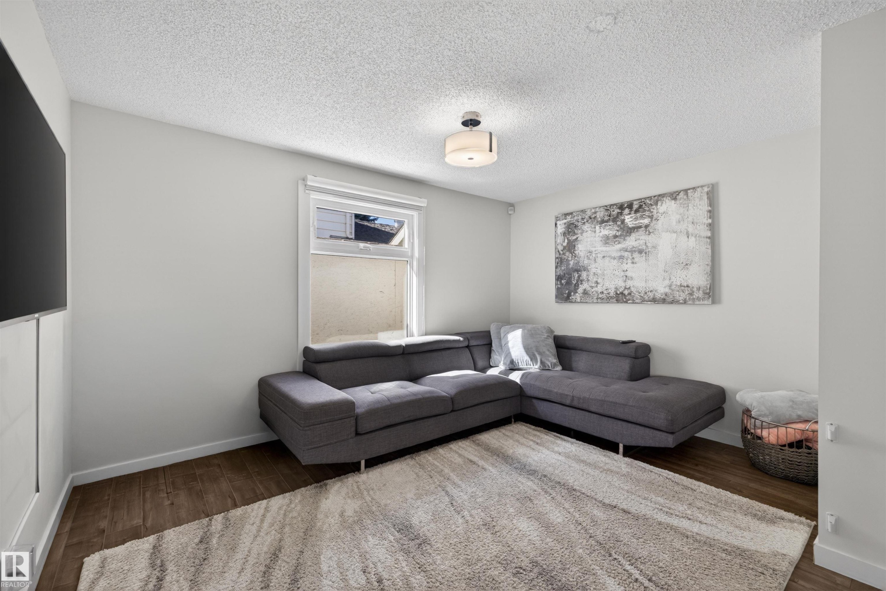 Living area featuring wood-finish flooring, a neutral color palette, and a window for natural light - 15251 88A Street, Edmonton, AB - Indoor Photo Showing Living Room