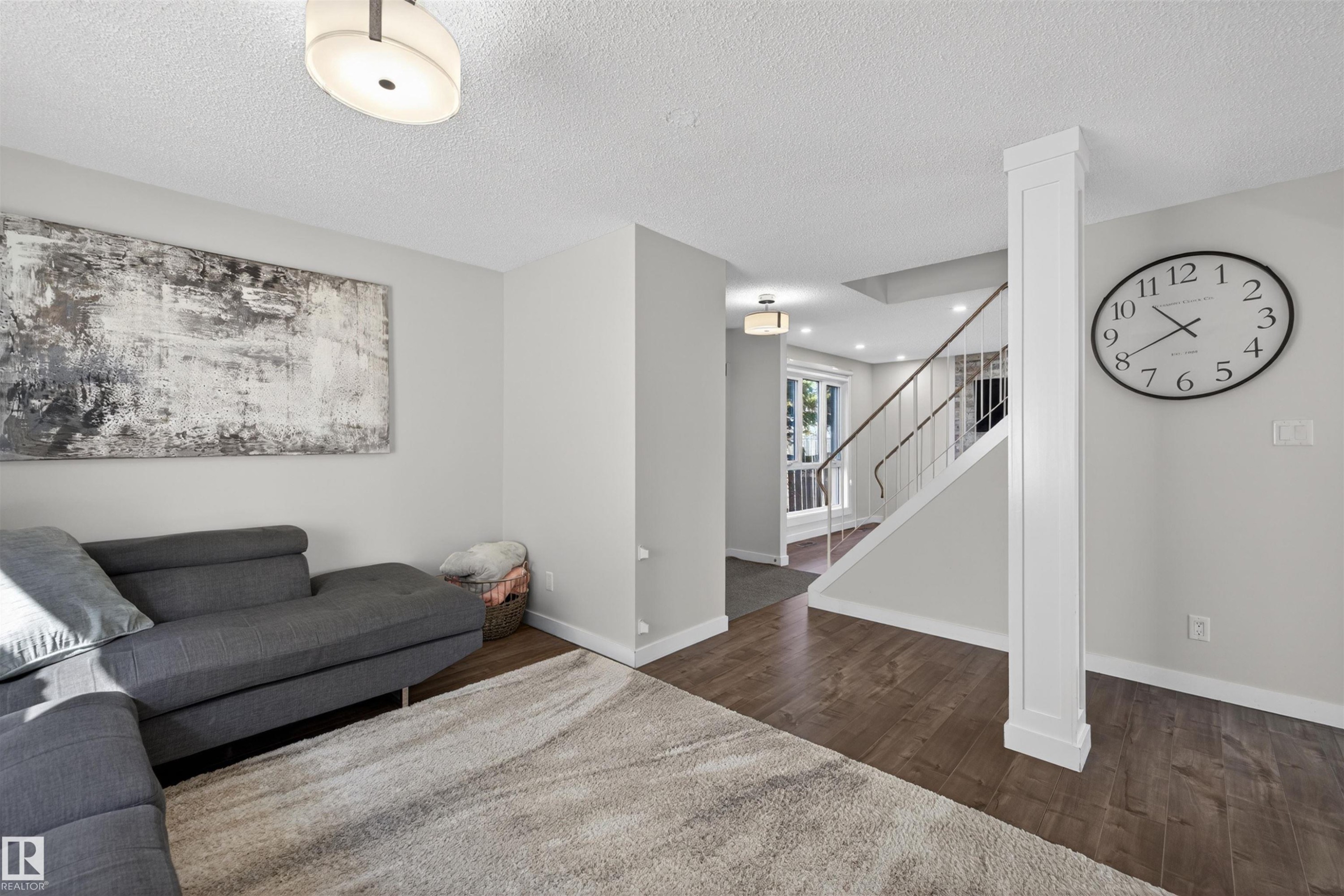 Spacious living area featuring wood-finish flooring and light grey wall tones - 15251 88A Street, Edmonton, AB - Indoor
