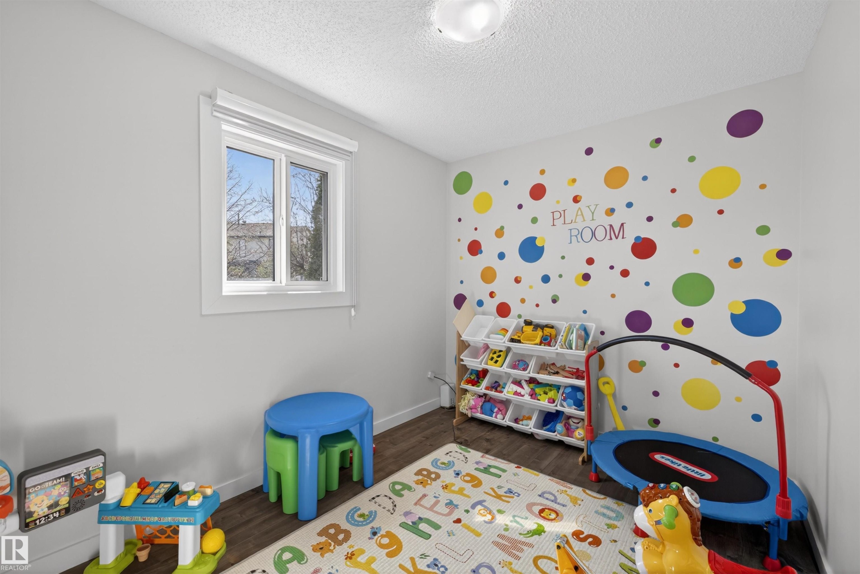 Room featuring wood-finish flooring, a contemporary window, and a ceiling-mounted light fixture - 15251 88A Street, Edmonton, AB - Indoor Photo Showing Bedroom
