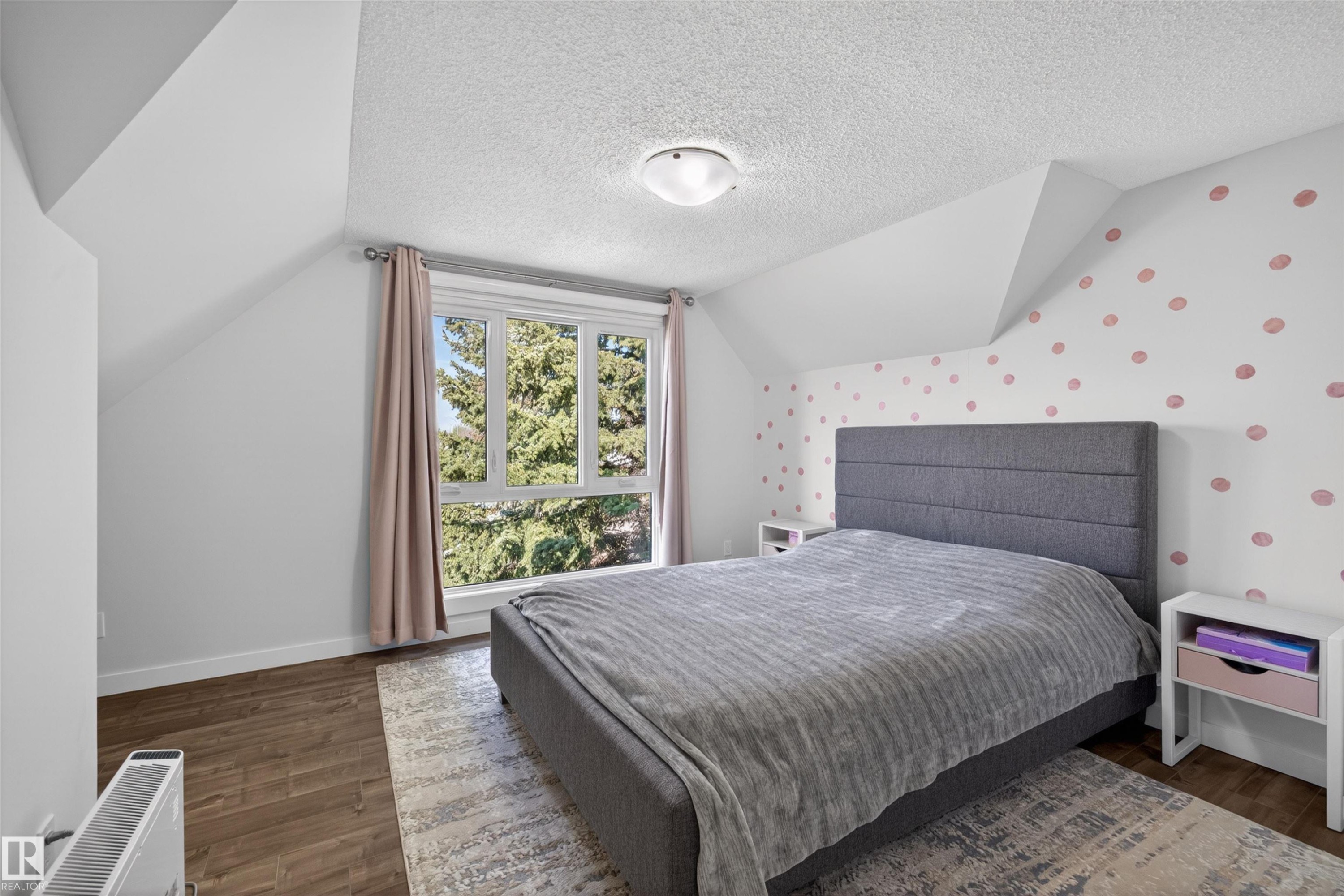 Spacious room featuring wood-finish flooring, a large window, sloped ceilings, and a flush mount ceiling light - 15251 88A Street, Edmonton, AB - Indoor Photo Showing Bedroom