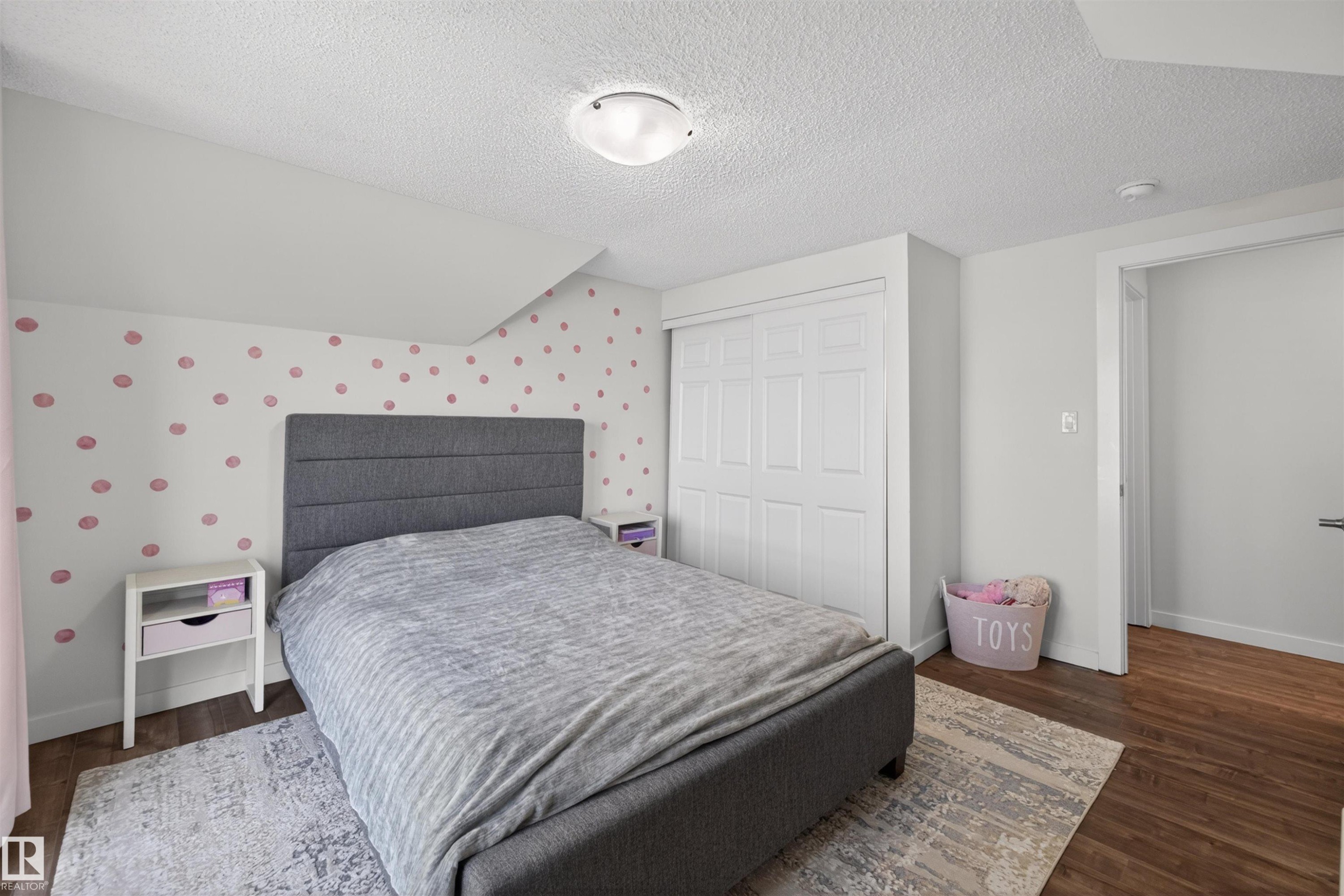 Bedroom featuring wood-finish flooring, a flush-mount ceiling light, and white bi-fold closet doors - 15251 88A Street, Edmonton, AB - Indoor Photo Showing Bedroom