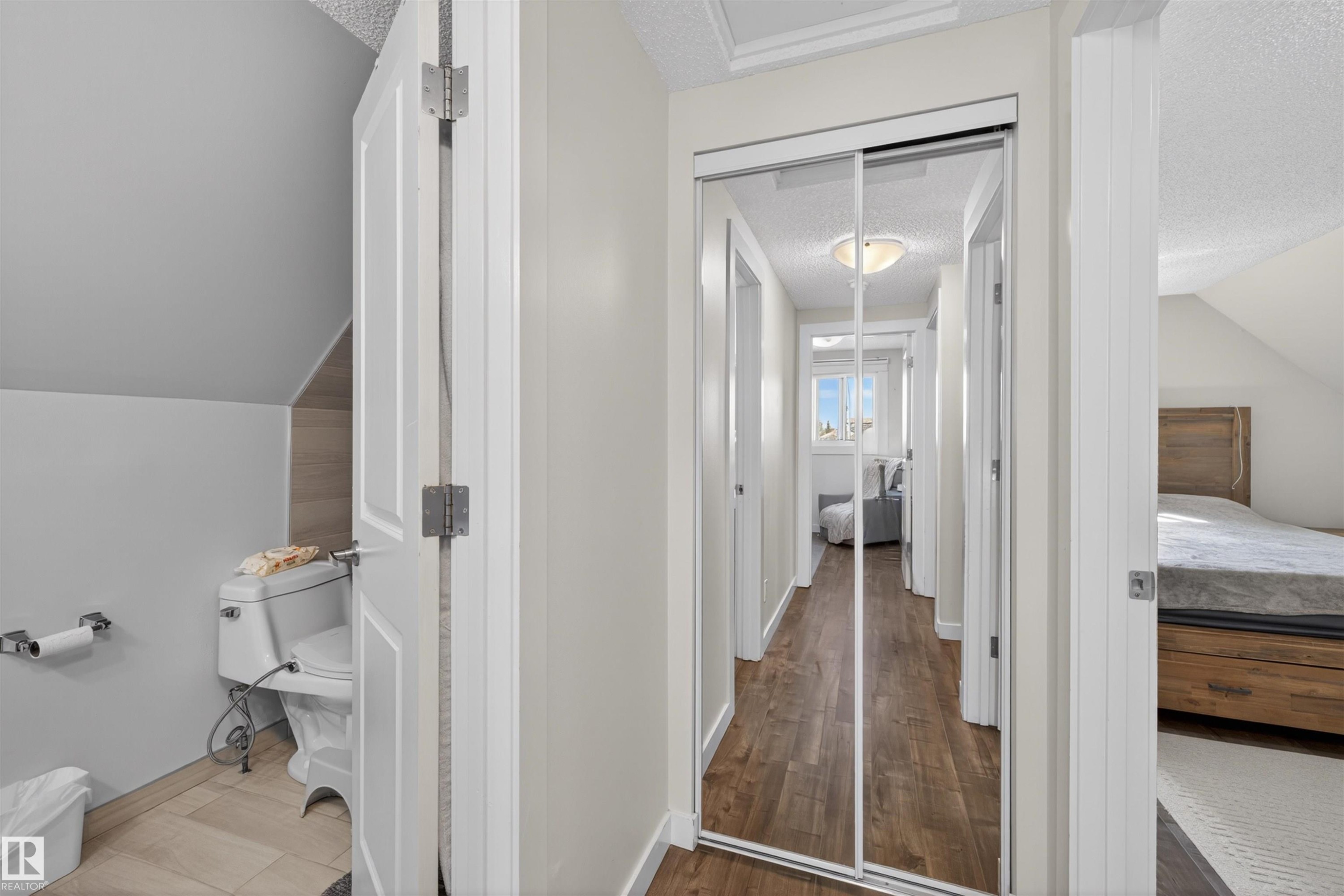 Hallway featuring wood-finish flooring, mirrored closet doors, and recessed lighting - 15251 88A Street, Edmonton, AB - Indoor Photo Showing Other Room