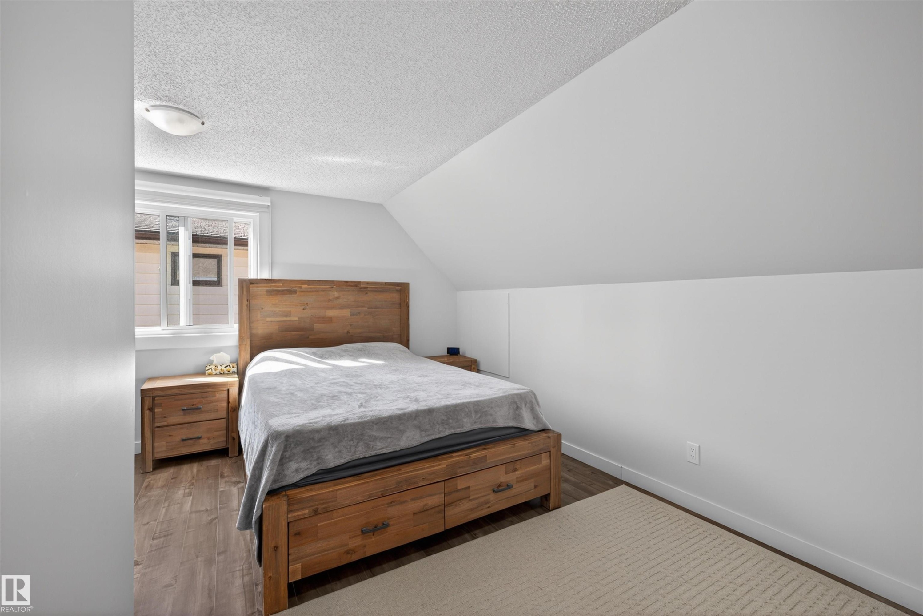 Bedroom featuring wood-finish flooring, a contemporary window, and a sloped ceiling design - 15251 88A Street, Edmonton, AB - Indoor Photo Showing Bedroom