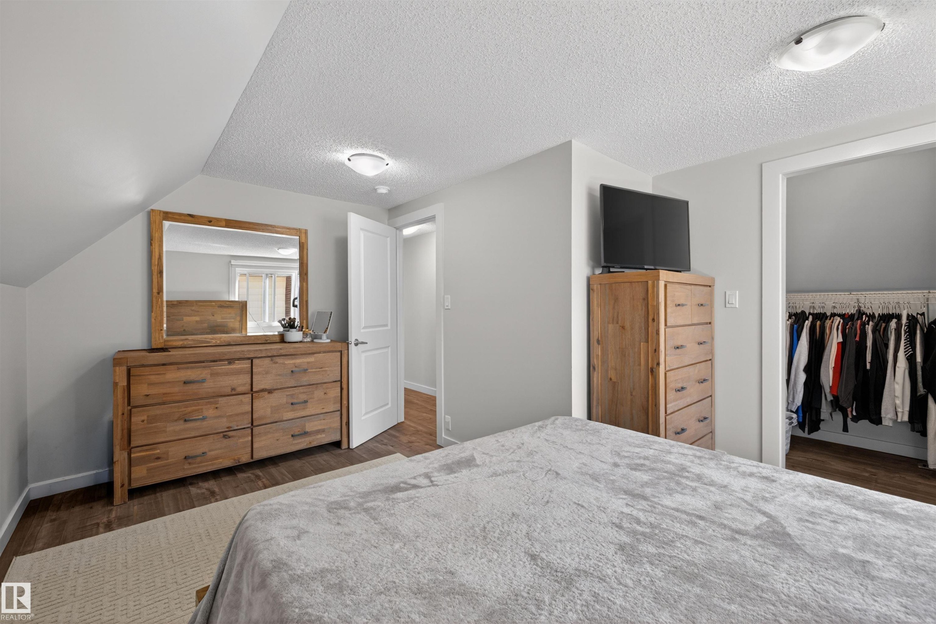 Bedroom featuring sloped ceilings, light gray wall paint, and wood-finish flooring - 15251 88A Street, Edmonton, AB - Indoor Photo Showing Bedroom