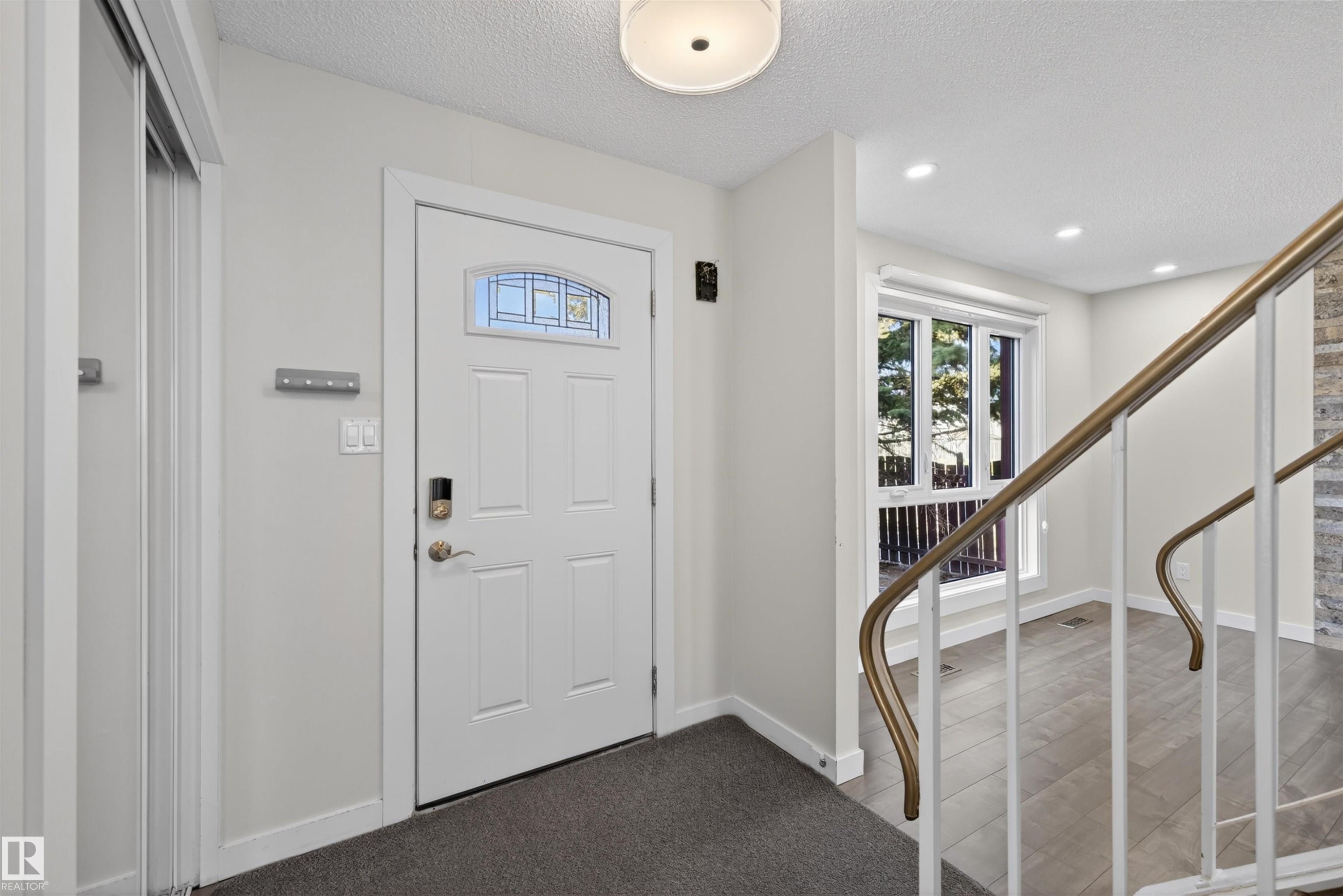 Entryway featuring a white paneled door with stained glass transom, smart lock, and a contemporary flush-mount ceiling light - 15251 88A Street, Edmonton, AB - Indoor Photo Showing Other Room