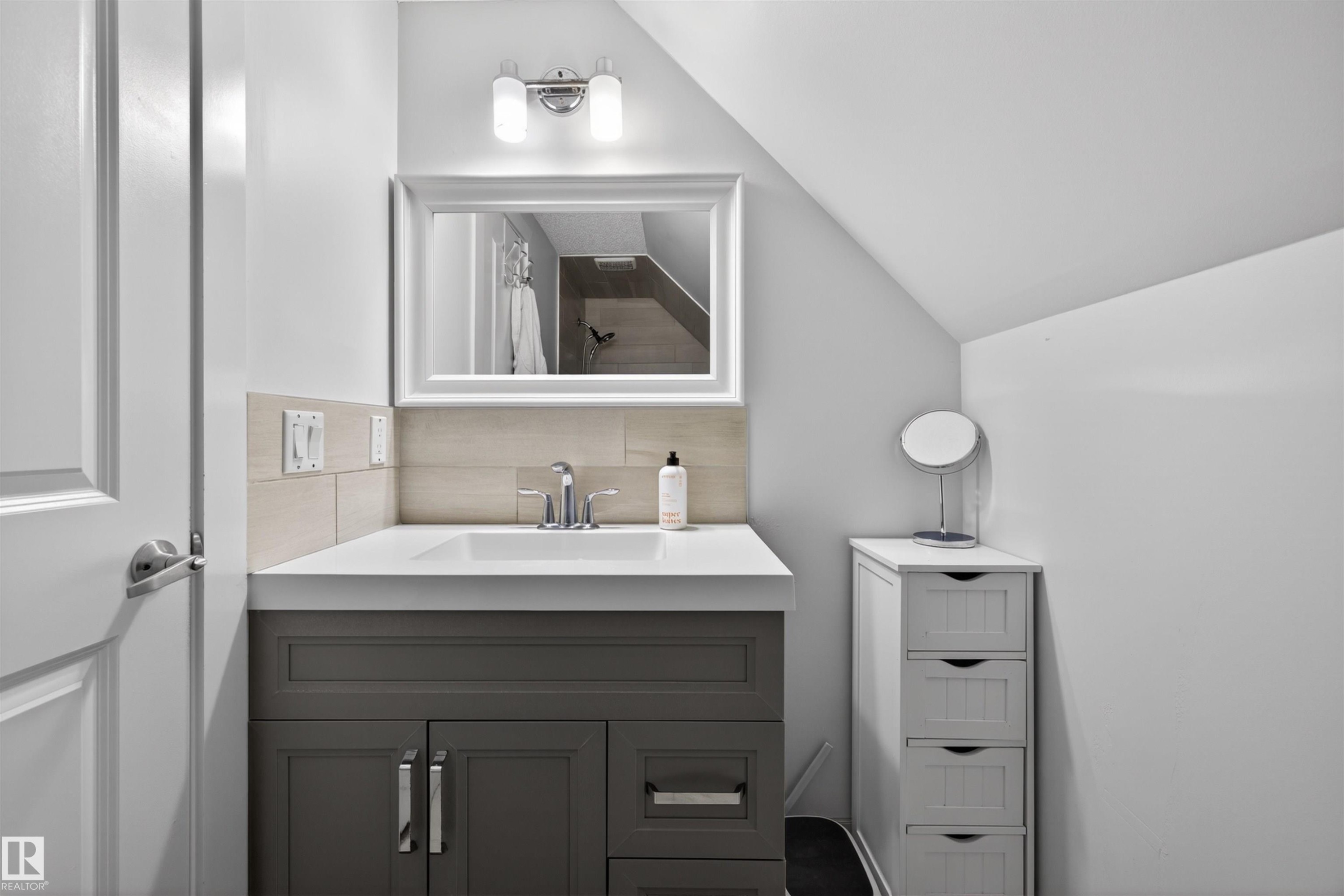 Bathroom featuring a gray vanity with chrome hardware, an undermount sink, and a white countertop - 15251 88A Street, Edmonton, AB - Indoor