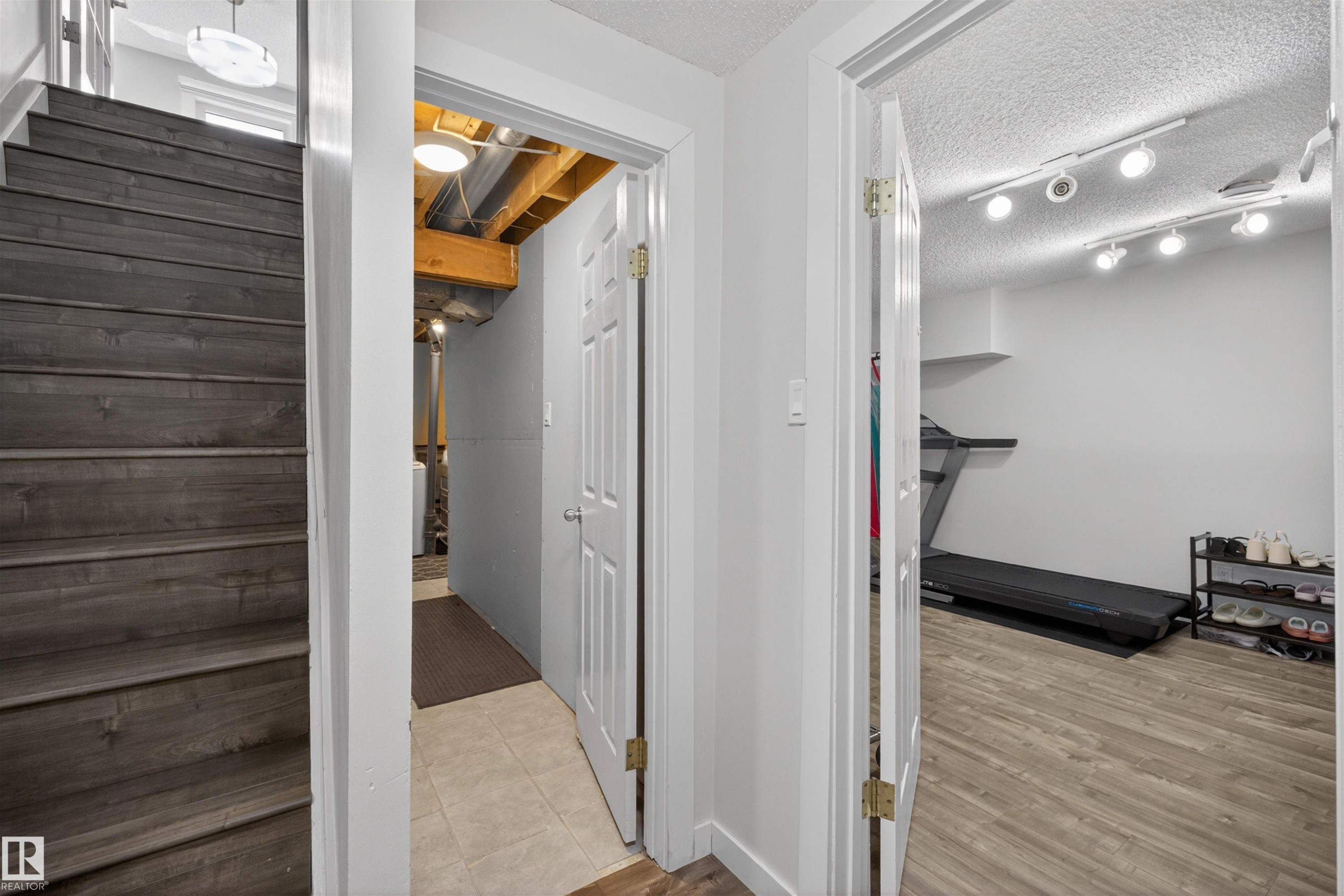 Wood-finish stairs with white risers and a partial white wall - 15251 88A Street, Edmonton, AB - Indoor Photo Showing Other Room