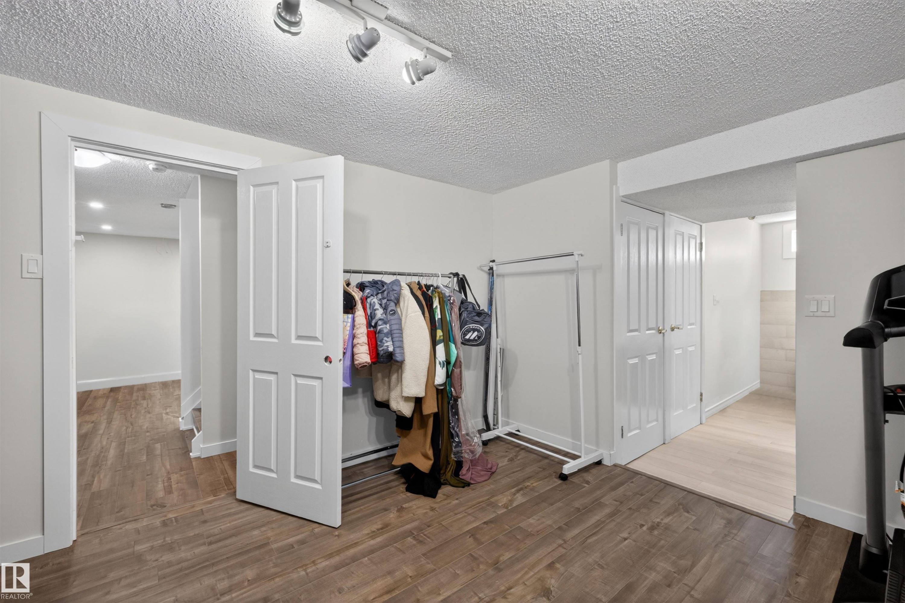 Recessed ceiling lighting and track lighting illuminate the room featuring wood-finish flooring - 15251 88A Street, Edmonton, AB - Indoor Photo Showing Other Room