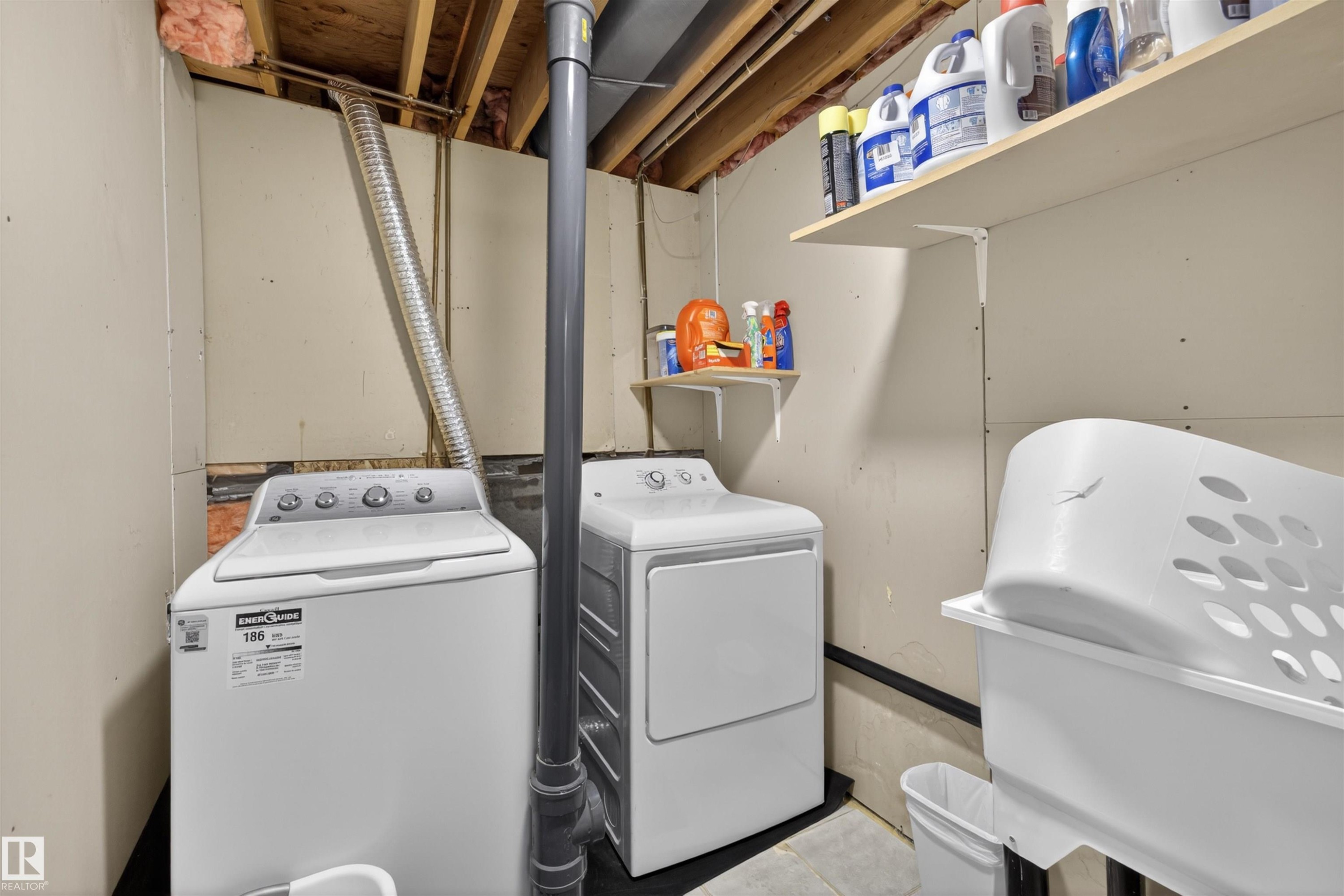 Dedicated laundry area with exposed ceiling joists and utilities, featuring shelving, a washer, a dryer, and a utility sink - 15251 88A Street, Edmonton, AB - Indoor Photo Showing Laundry Room