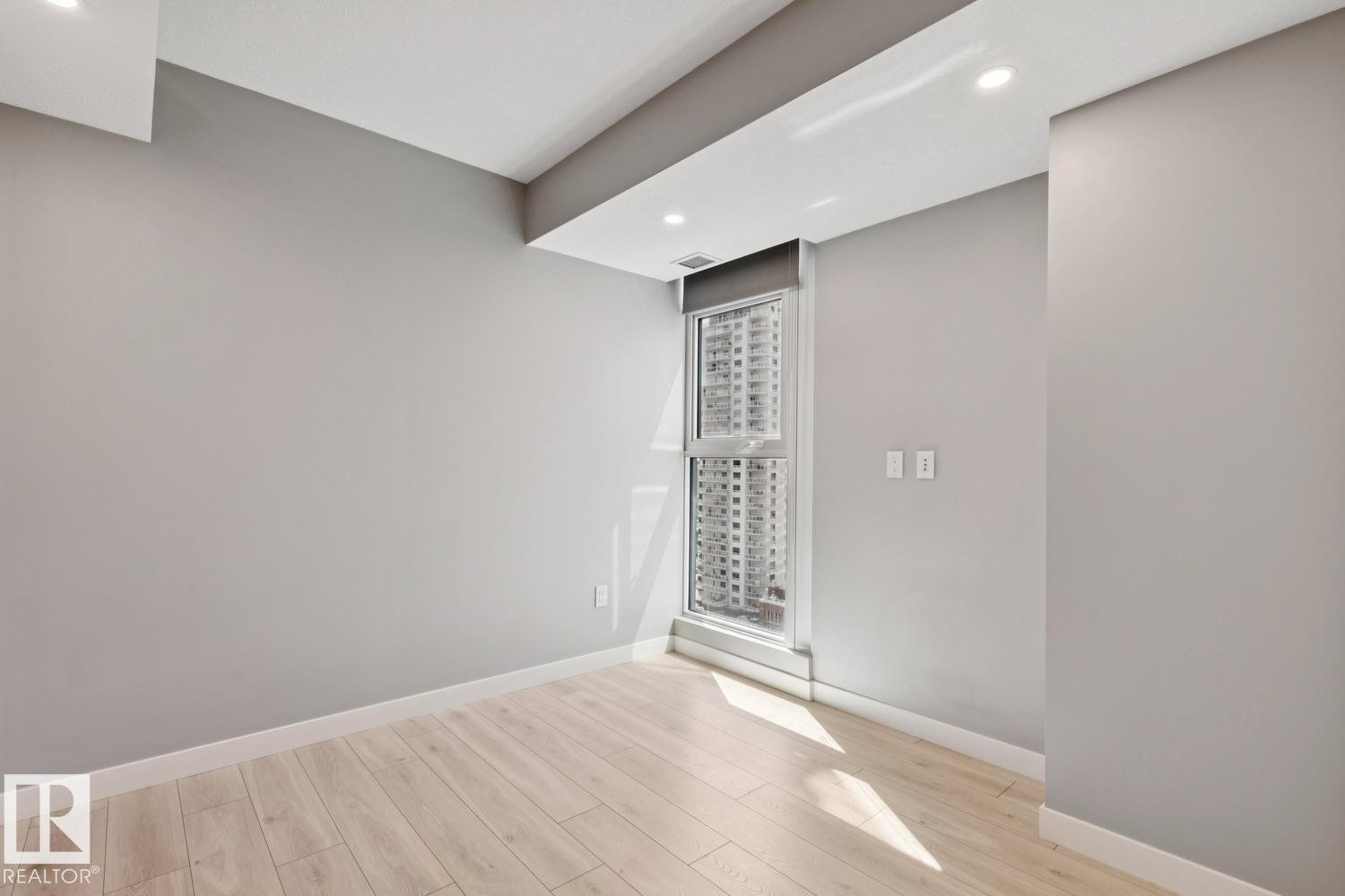 Room featuring light wood-finish flooring, light grey painted walls, and white trim - #1601 10180 103 St Nw, Edmonton, AB - Indoor Photo Showing Other Room