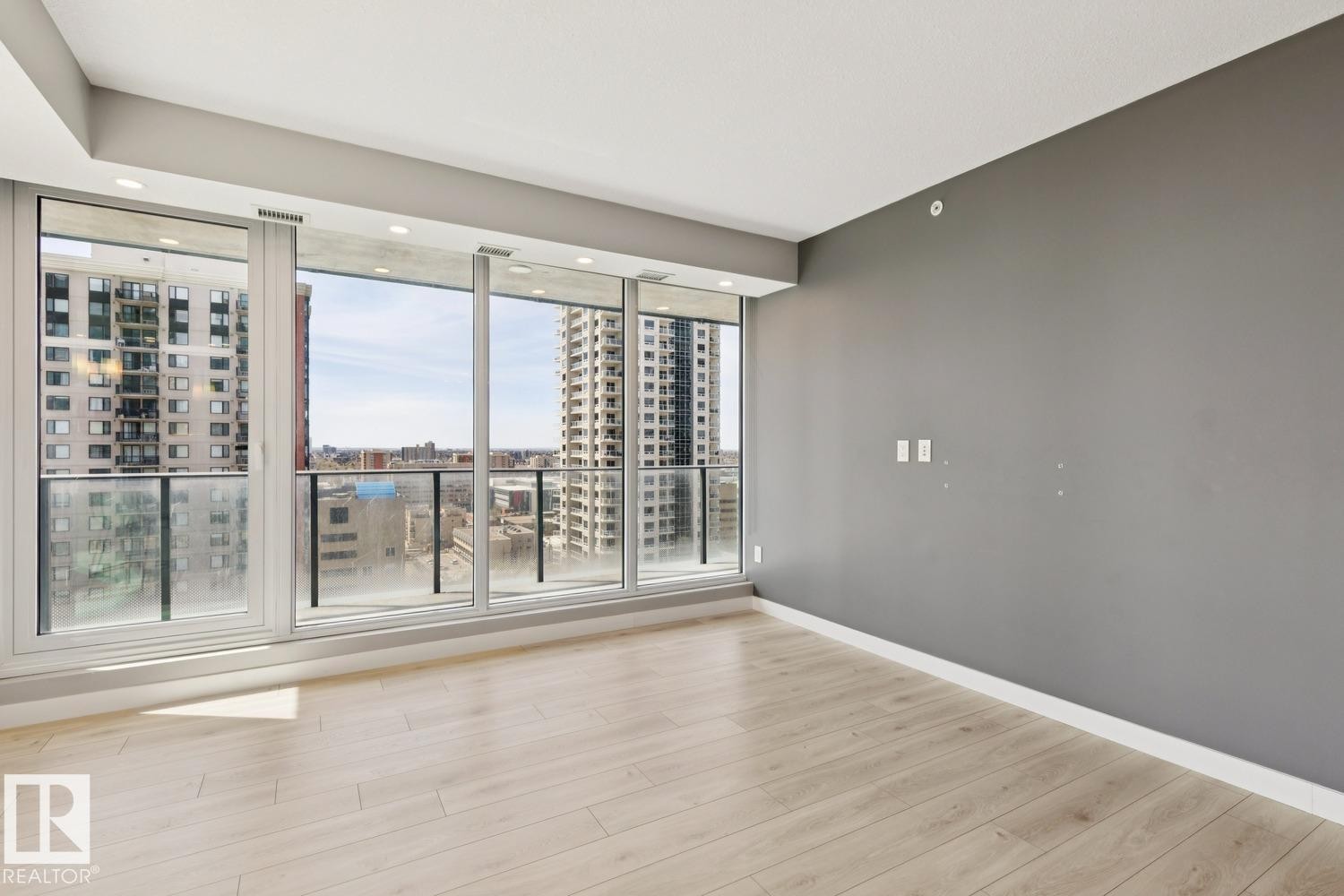 Expansive window wall with a glass balcony railing - #1601 10180 103 St Nw, Edmonton, AB - Indoor Photo Showing Other Room