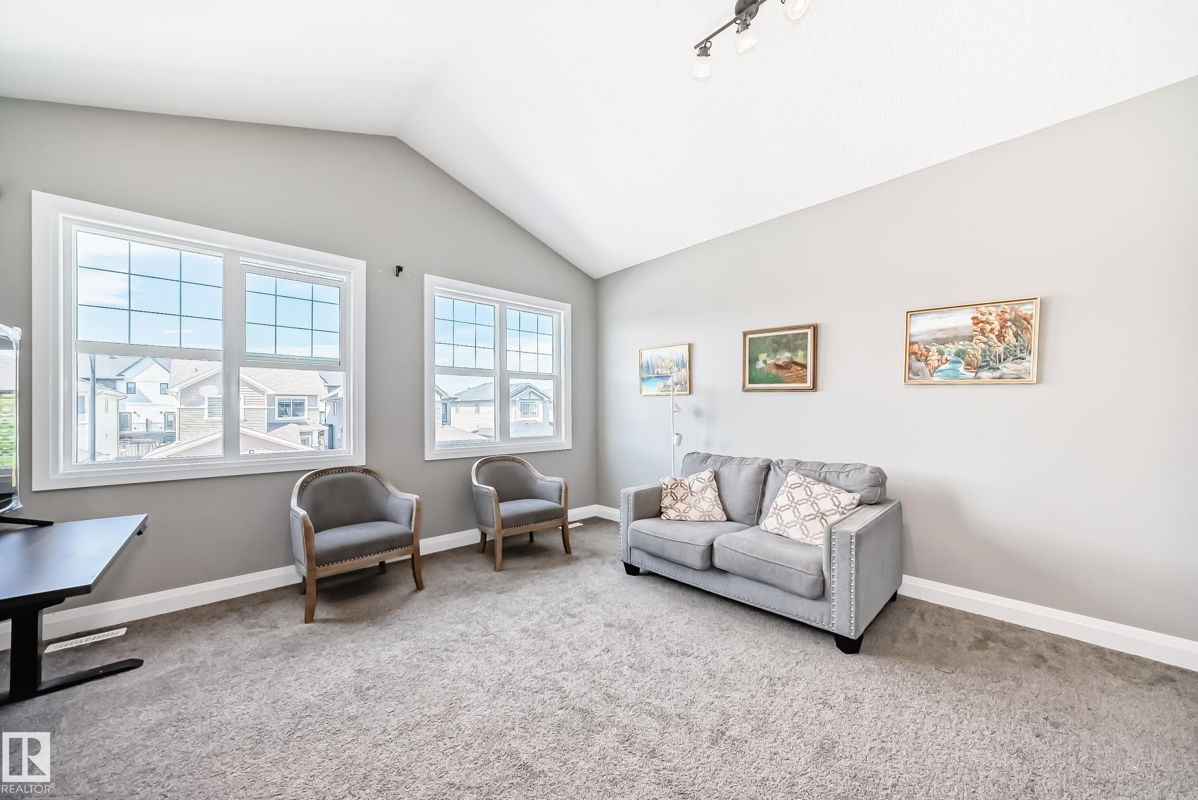 Spacious room featuring a vaulted ceiling and neutral-toned walls - 4155 Charles Link, Edmonton, AB - Indoor