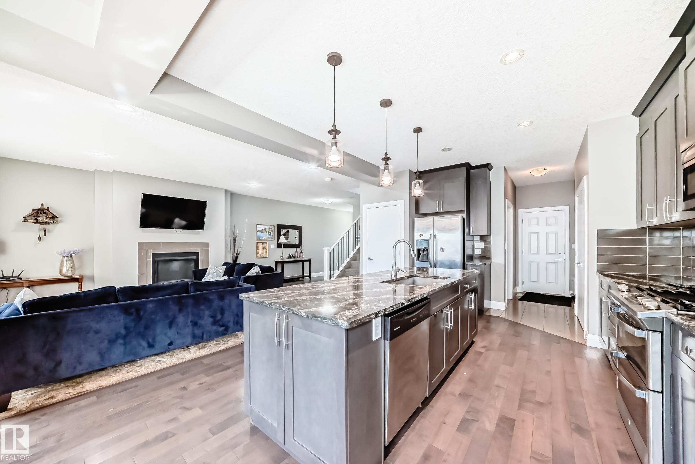 Open concept kitchen featuring a large island with a stone countertop and pendant lighting - 4155 Charles Link, Edmonton, AB - Indoor Photo Showing Kitchen With Stainless Steel Kitchen With Upgraded Kitchen