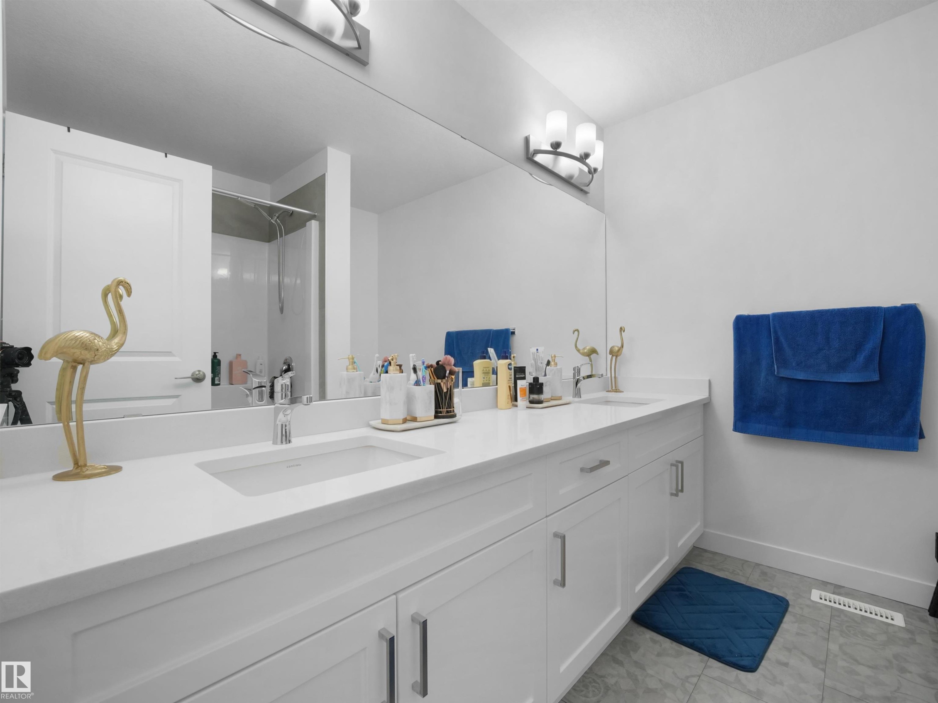 Double vanity with an integrated rectangular sink, white countertop, and white cabinetry featuring brushed nickel hardware - 30 Hope Cm, Spruce Grove, AB - Indoor Photo Showing Bathroom