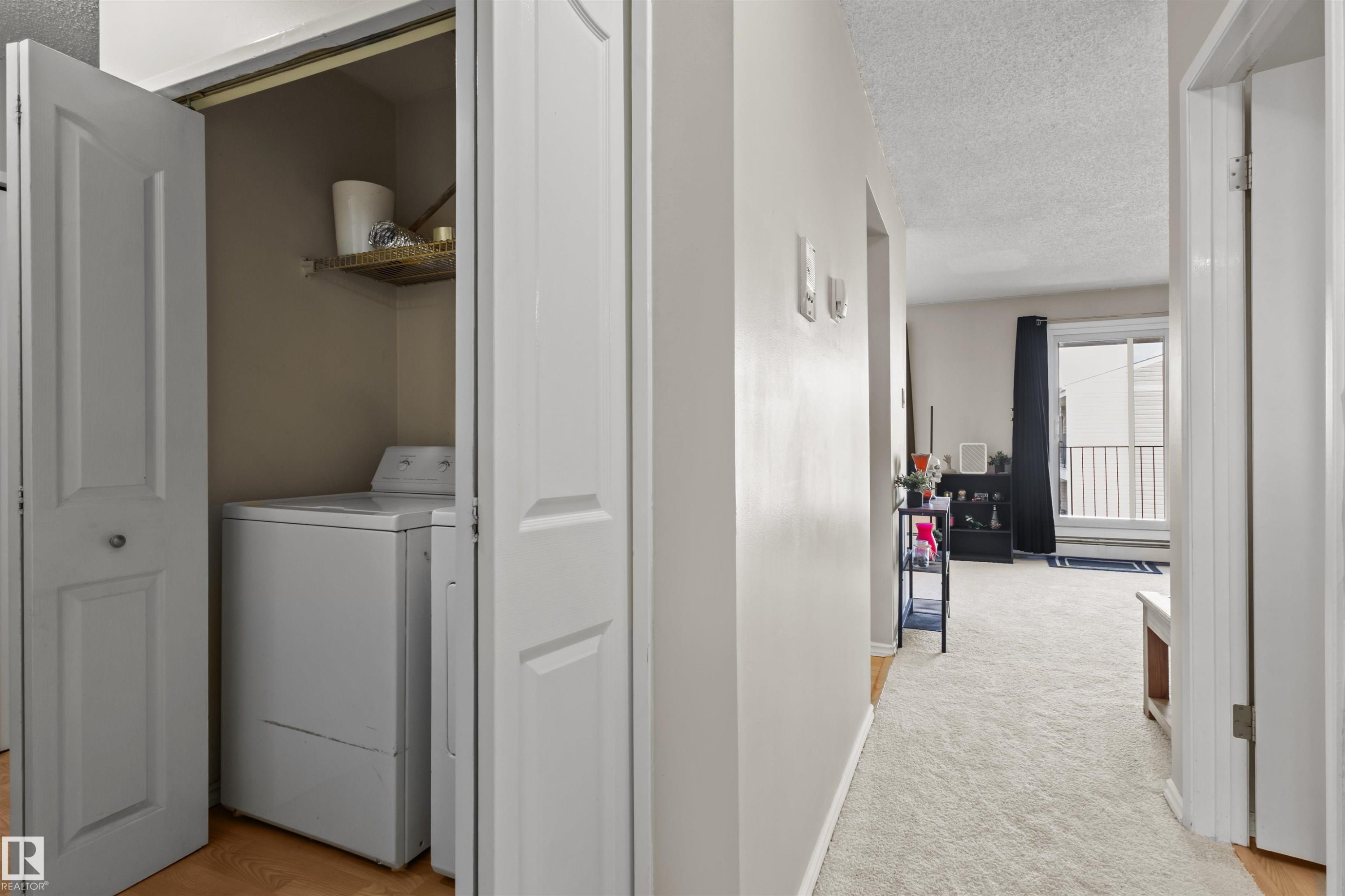 In-unit laundry closet with bi-fold doors and a built-in shelf - 6 3803 76 Street, Edmonton, AB - Indoor Photo Showing Laundry Room