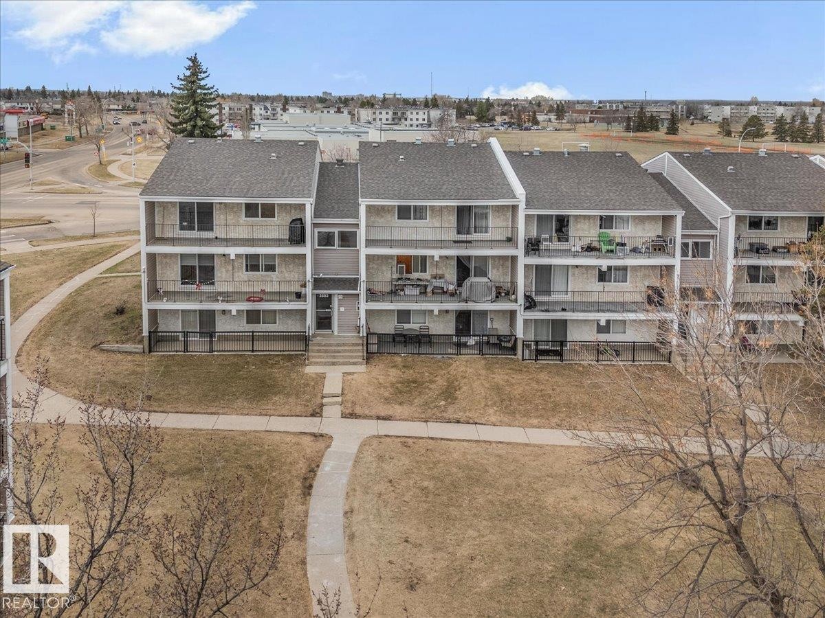 Multi-level residential building featuring private balconies, individual patios, and a central entryway with concrete steps - 6 3803 76 Street, Edmonton, AB - Outdoor