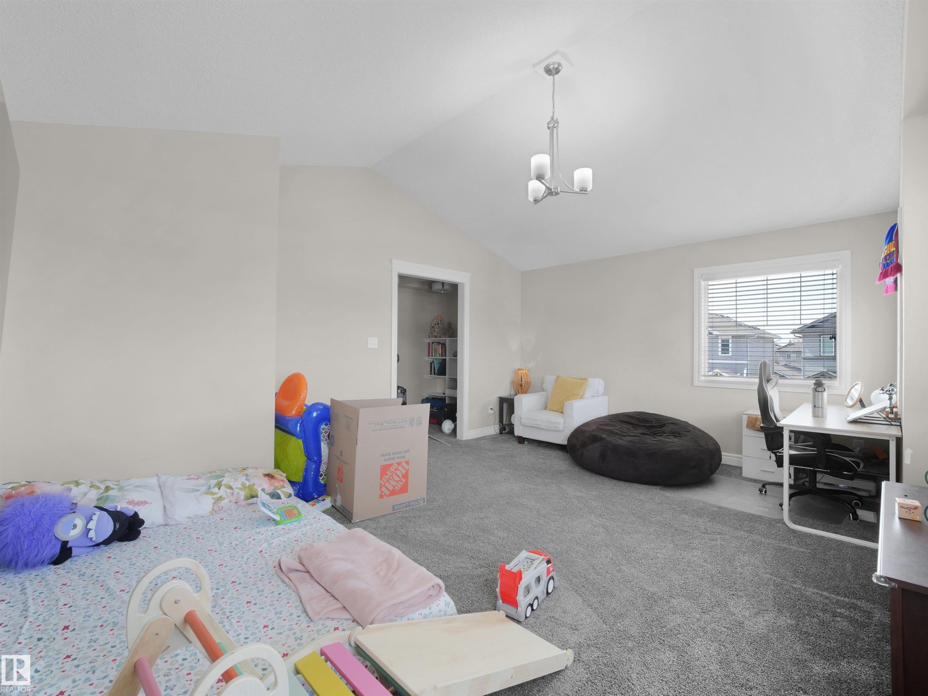 Carpeted room with a vaulted ceiling, a chandelier light fixture, and a window with horizontal blinds - 3247 15 Avenue Nw, Edmonton, AB - Indoor Photo Showing Bedroom