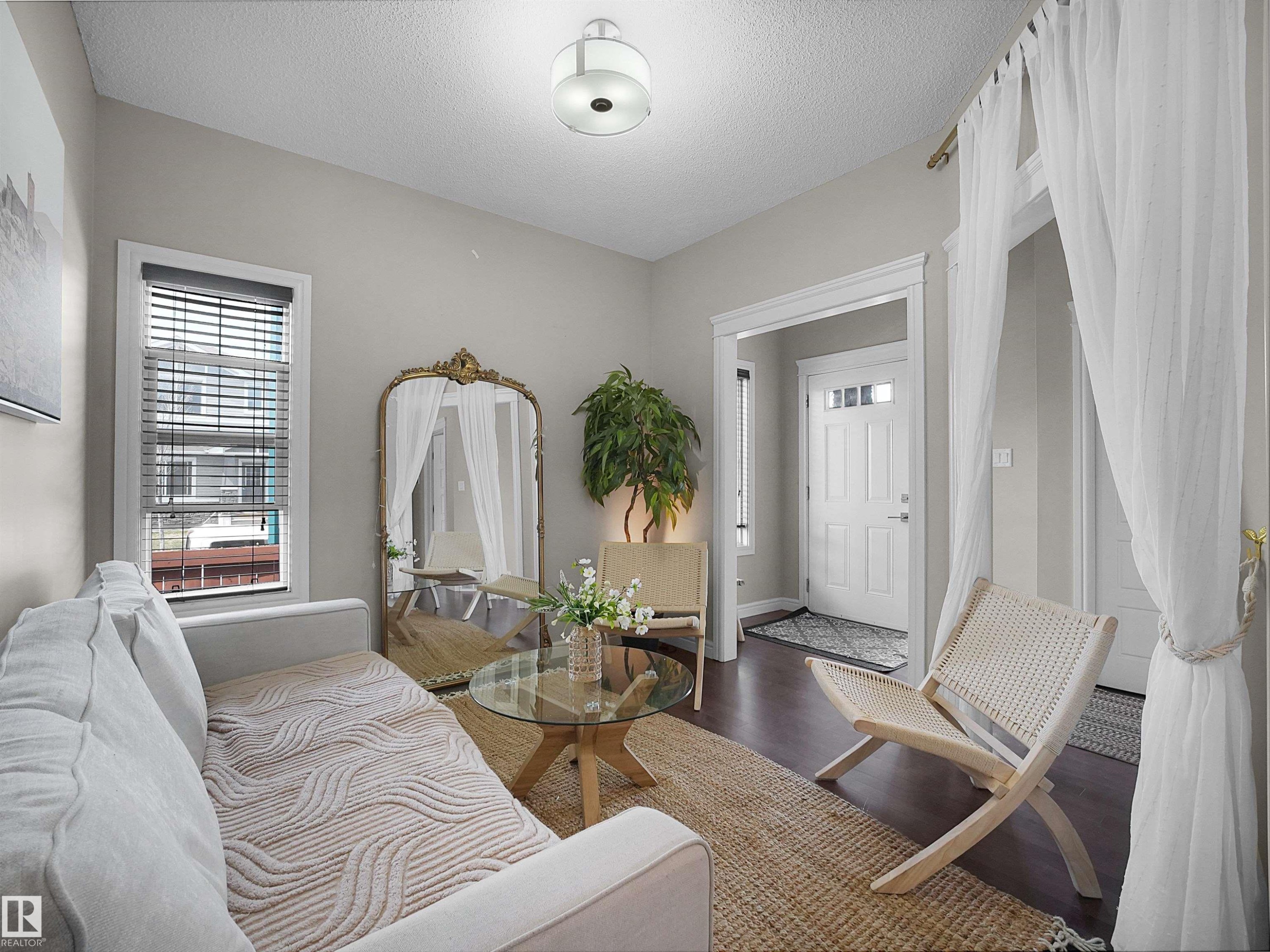 Living area featuring dark wood-finish flooring and light gray wall tones - 3247 15 Avenue Nw, Edmonton, AB - Indoor Photo Showing Bedroom