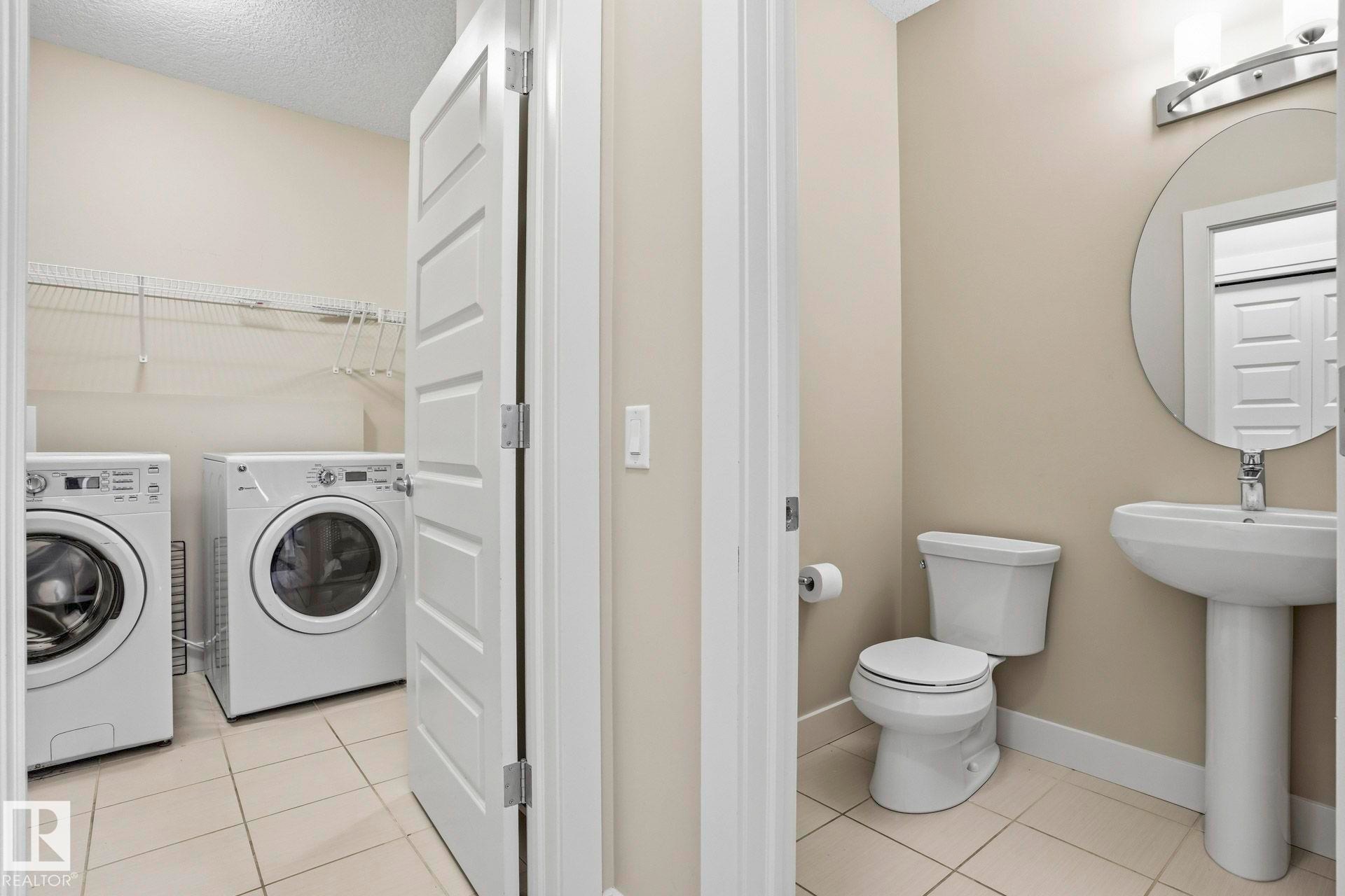 Half bathroom with light tile patterned floors, a textured ceiling, and separate washer and dryer - 1915 77 Street, Edmonton, AB - Indoor Photo Showing Laundry Room