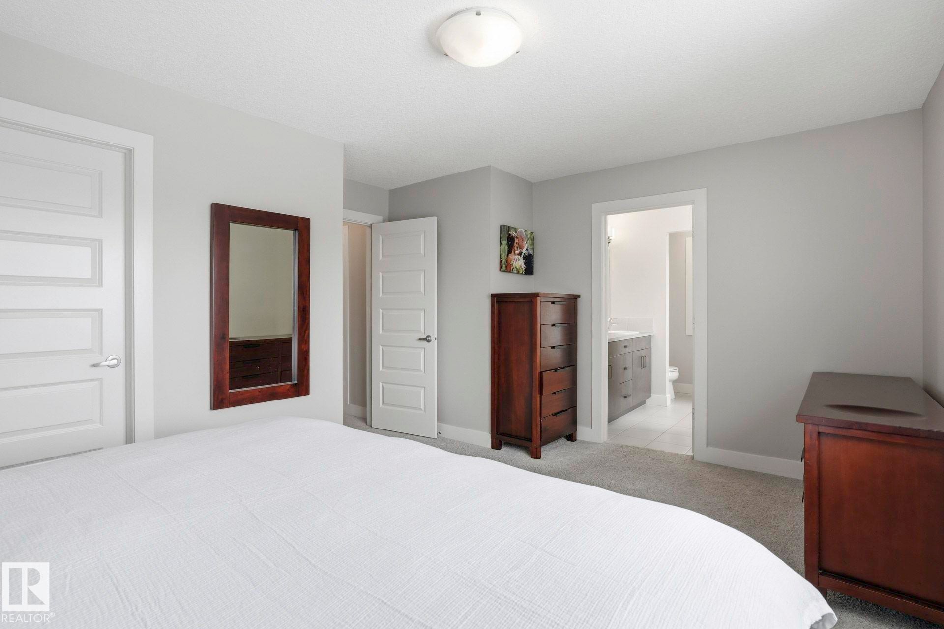 Bedroom featuring light carpet and connected bathroom - 1915 77 Street, Edmonton, AB - Indoor Photo Showing Bedroom