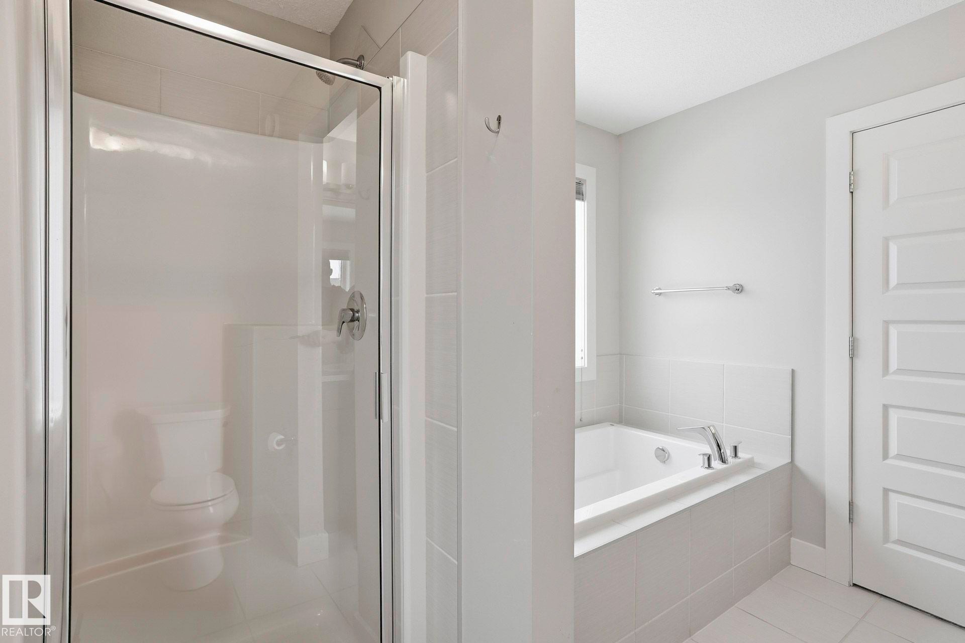Full bathroom with a shower stall, a bath, and light tile patterned flooring - 1915 77 Street, Edmonton, AB - Indoor Photo Showing Bathroom