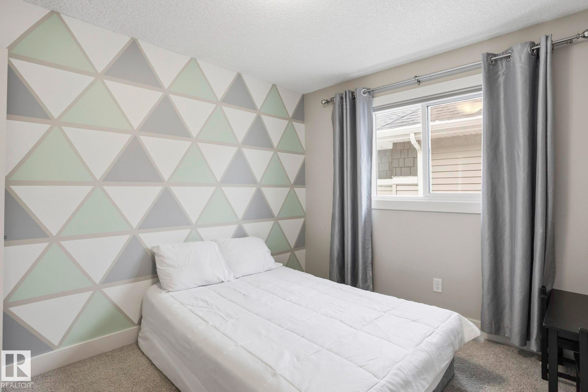 Bedroom with carpet floors, a textured ceiling, and an accent wall - 1915 77 Street, Edmonton, AB - Indoor Photo Showing Bedroom