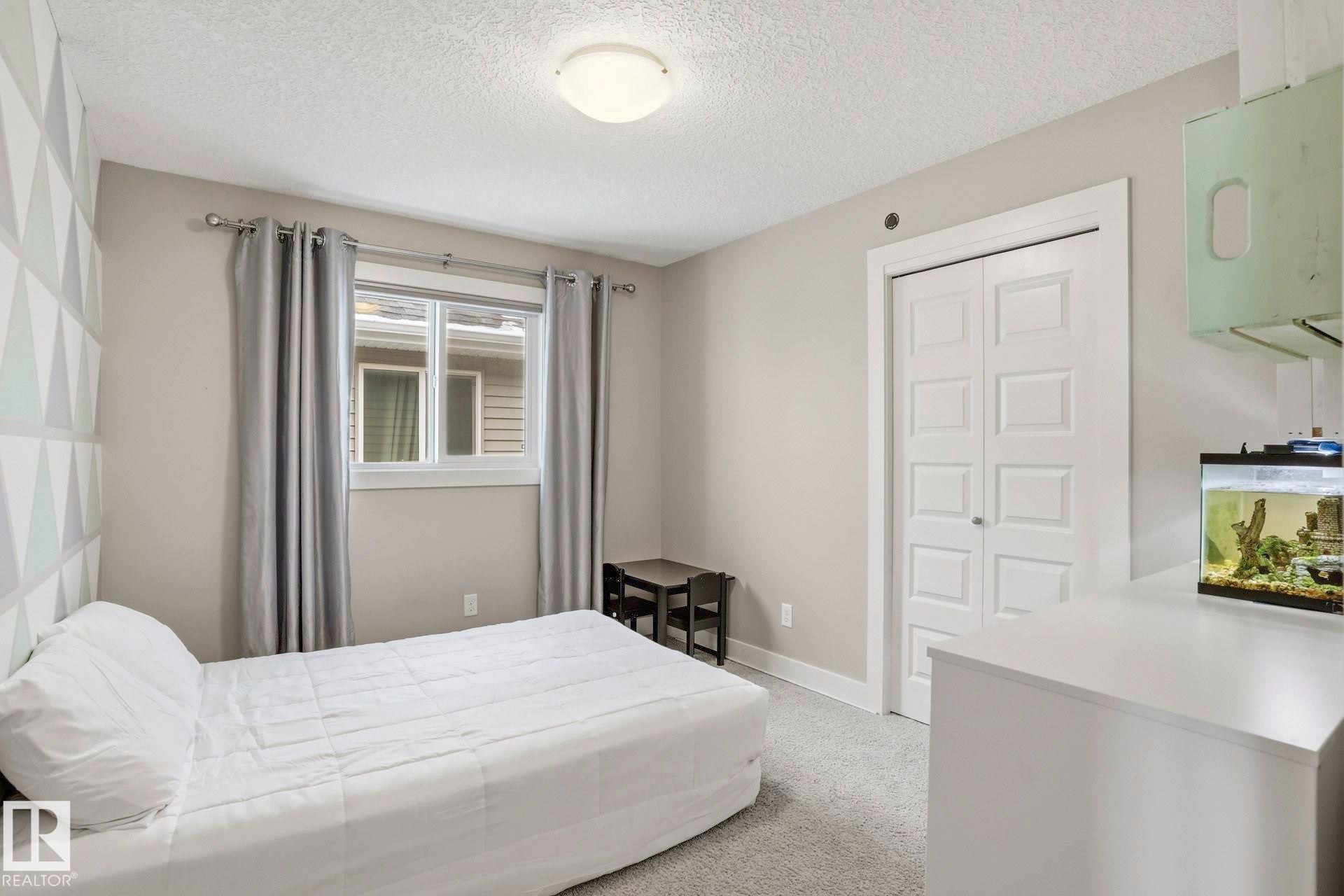 Bedroom with light carpet and a textured ceiling - 1915 77 Street, Edmonton, AB - Indoor Photo Showing Bedroom