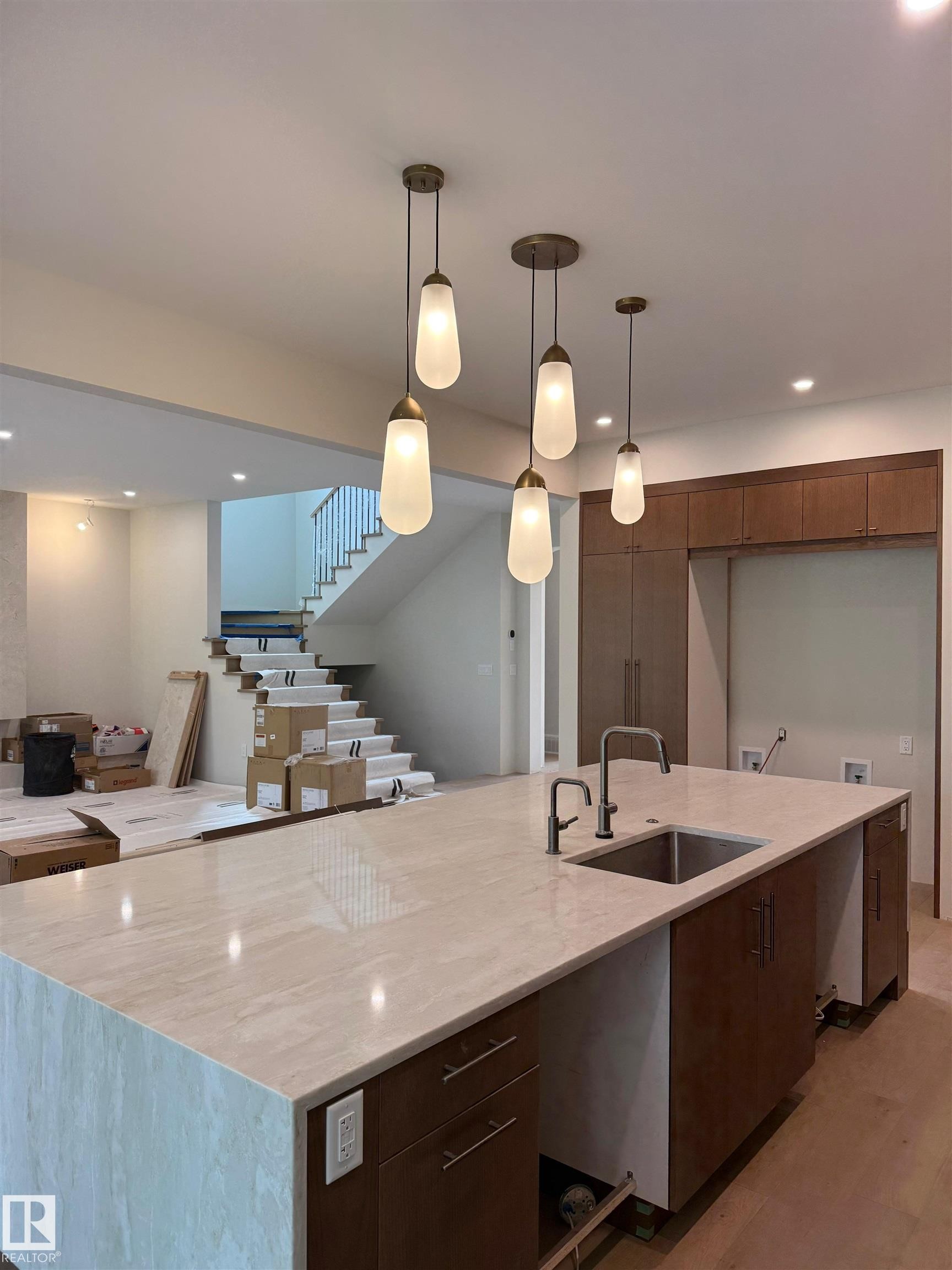 Kitchen island featuring a light-toned countertop, an undermount sink with a gooseneck faucet, and integrated cabinetry - 14702 Park Drive, Edmonton, AB - Indoor Photo Showing Kitchen With Upgraded Kitchen