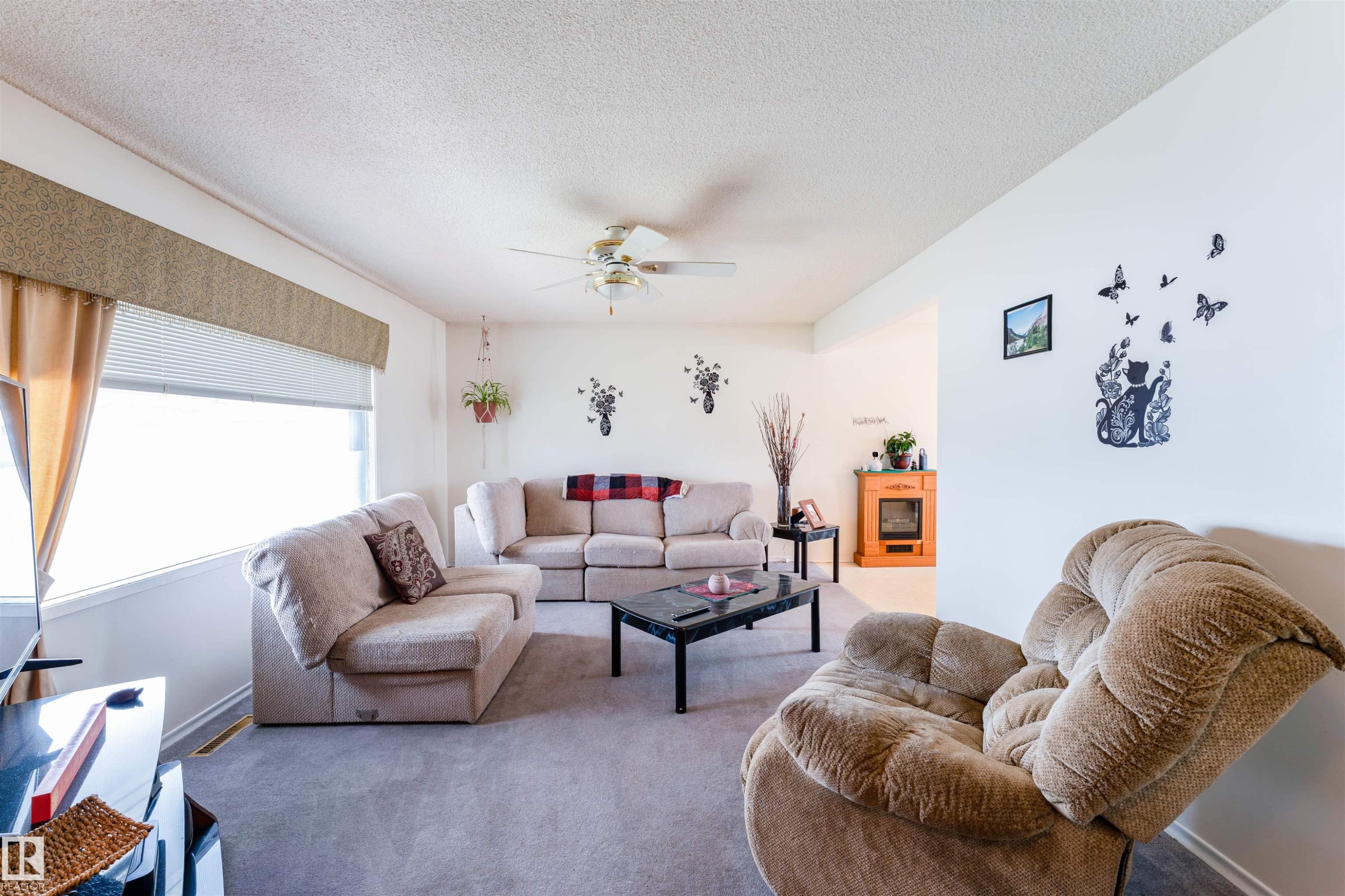 Spacious living area featuring light-toned carpeting and white wall finishes - 13231 74 Street, Edmonton, AB - Indoor Photo Showing Living Room