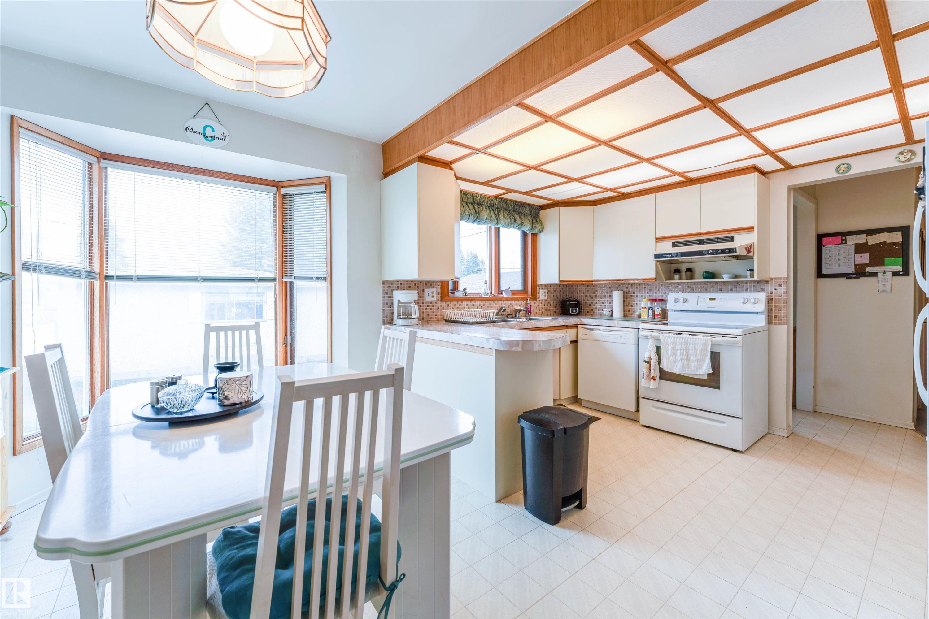 Kitchen with white cabinetry, white appliances, and a tiled backsplash - 13231 74 Street, Edmonton, AB - Indoor