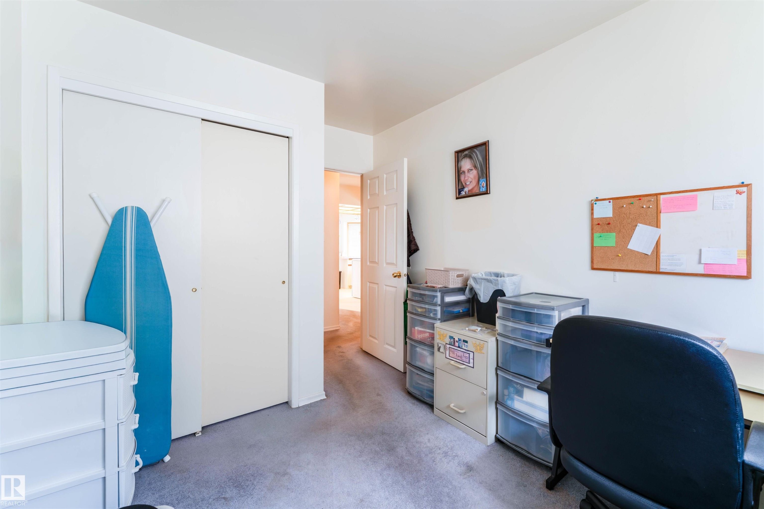 Room with light carpeting, a white interior door, and a built-in closet with white bifold doors - 13231 74 Street, Edmonton, AB - Indoor Photo Showing Office