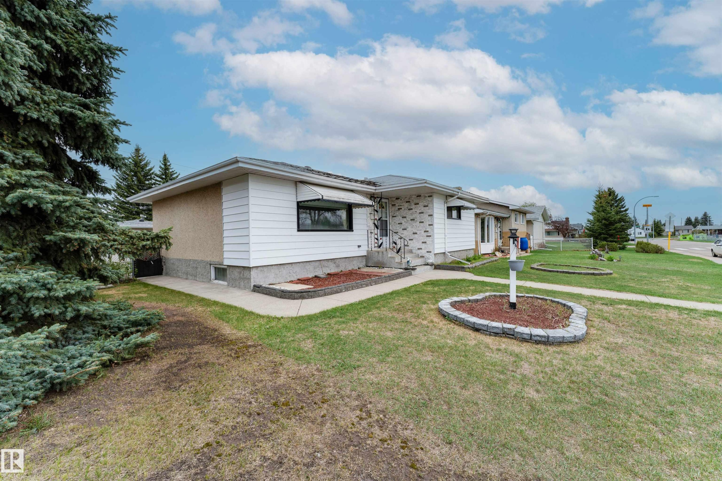 Side-gabled residence featuring white horizontal siding and a textured beige facade - 13231 74 Street, Edmonton, AB - Outdoor