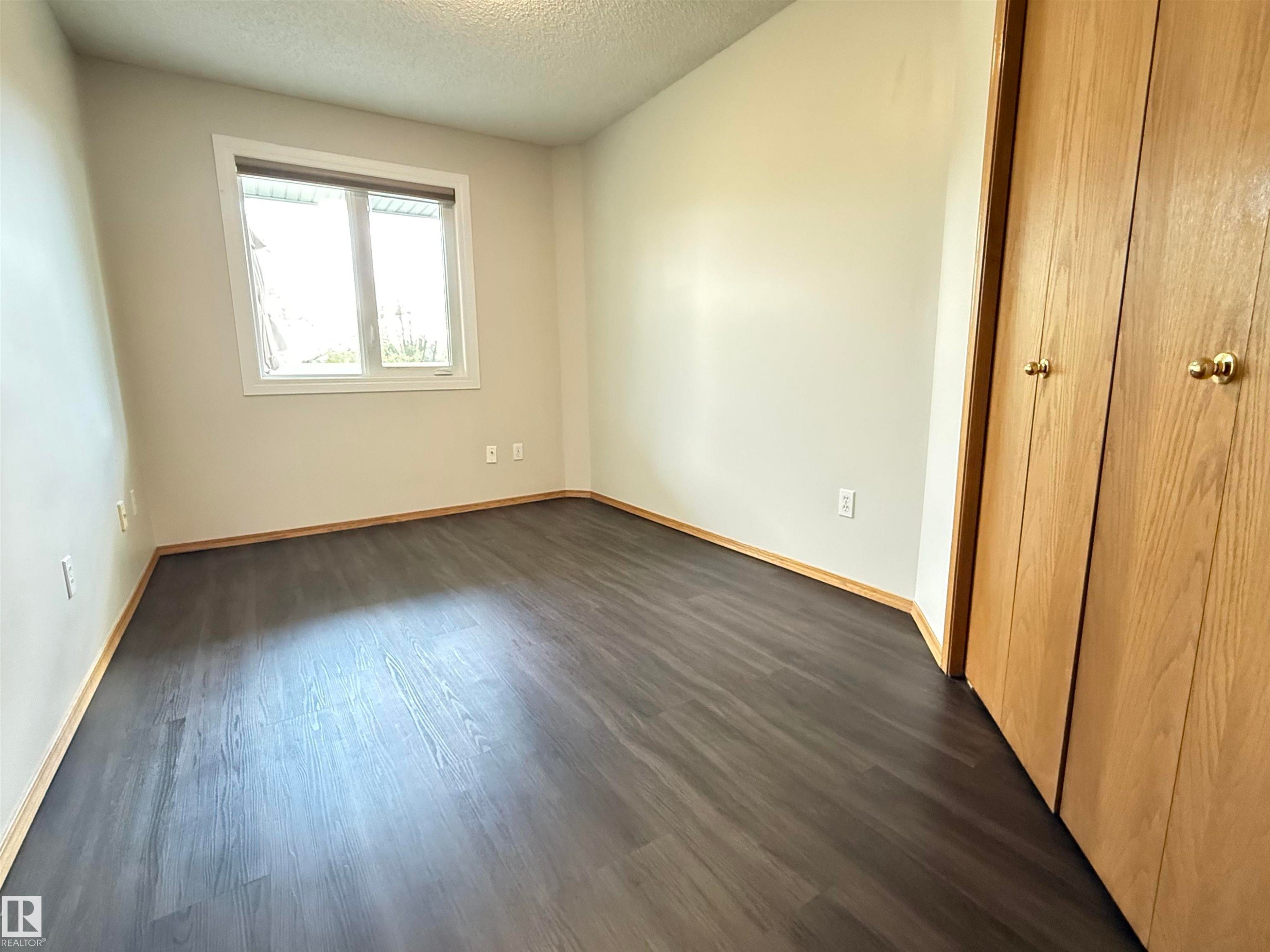 Interior room featuring wood-finish flooring and light-toned walls - #309 10610 76 St Nw, Edmonton, AB - Indoor Photo Showing Other Room