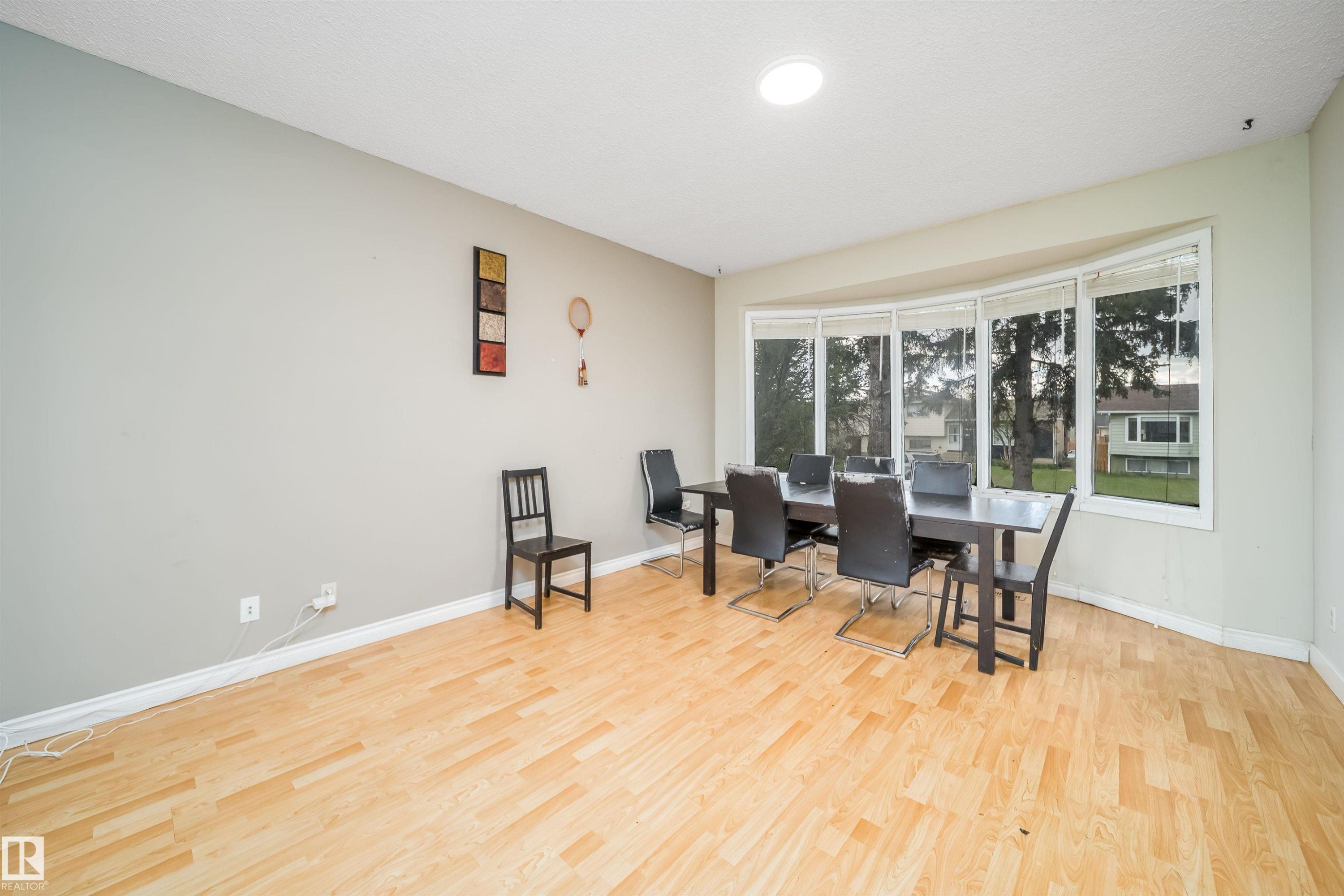 Bright room with wood-finish flooring and a wide bay window - 1771 37 Street, Edmonton, AB - Indoor Photo Showing Dining Room