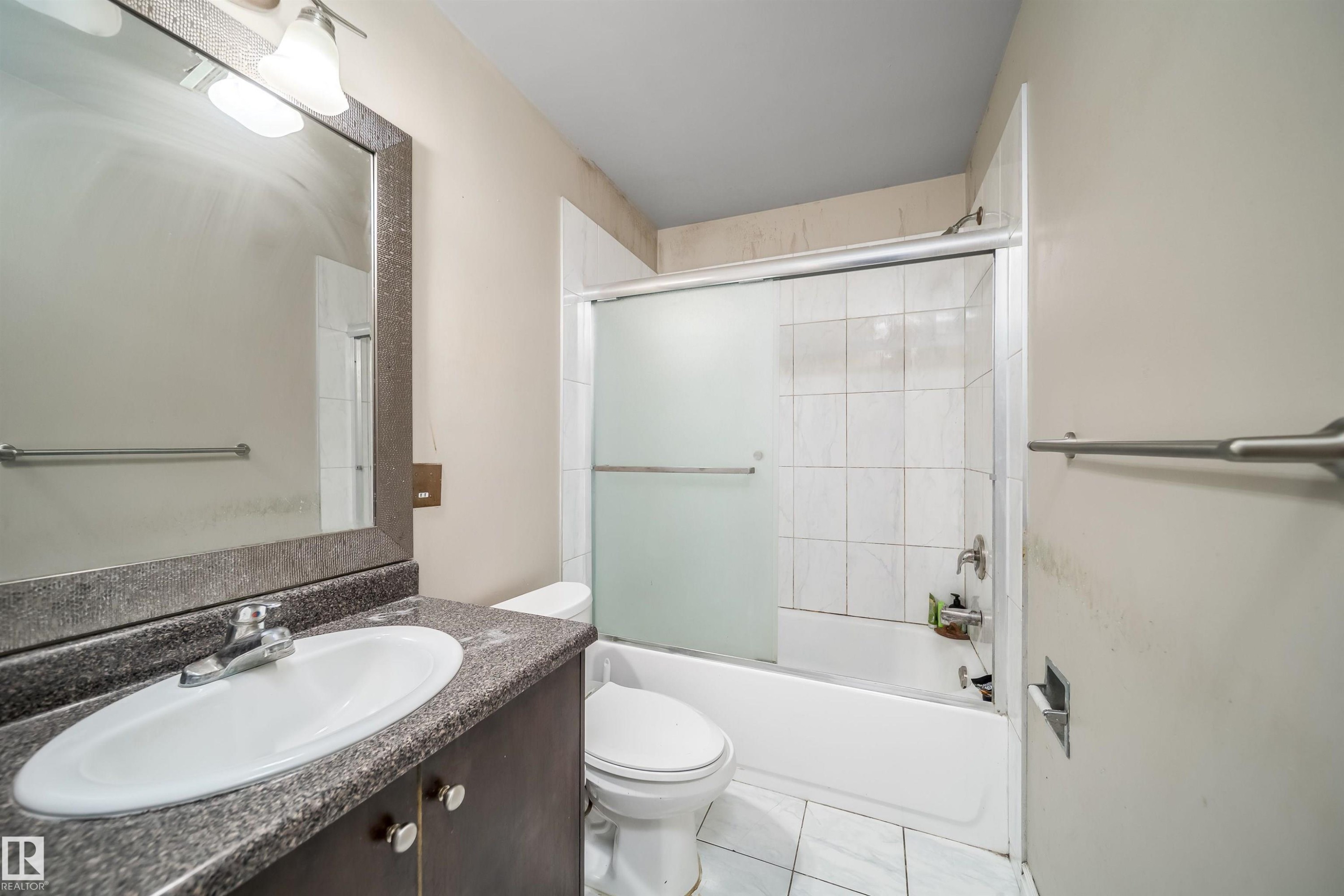 Bathroom featuring a dark wood-finish vanity with a speckled countertop and an oval undermount sink - 1771 37 Street, Edmonton, AB - Indoor Photo Showing Bathroom