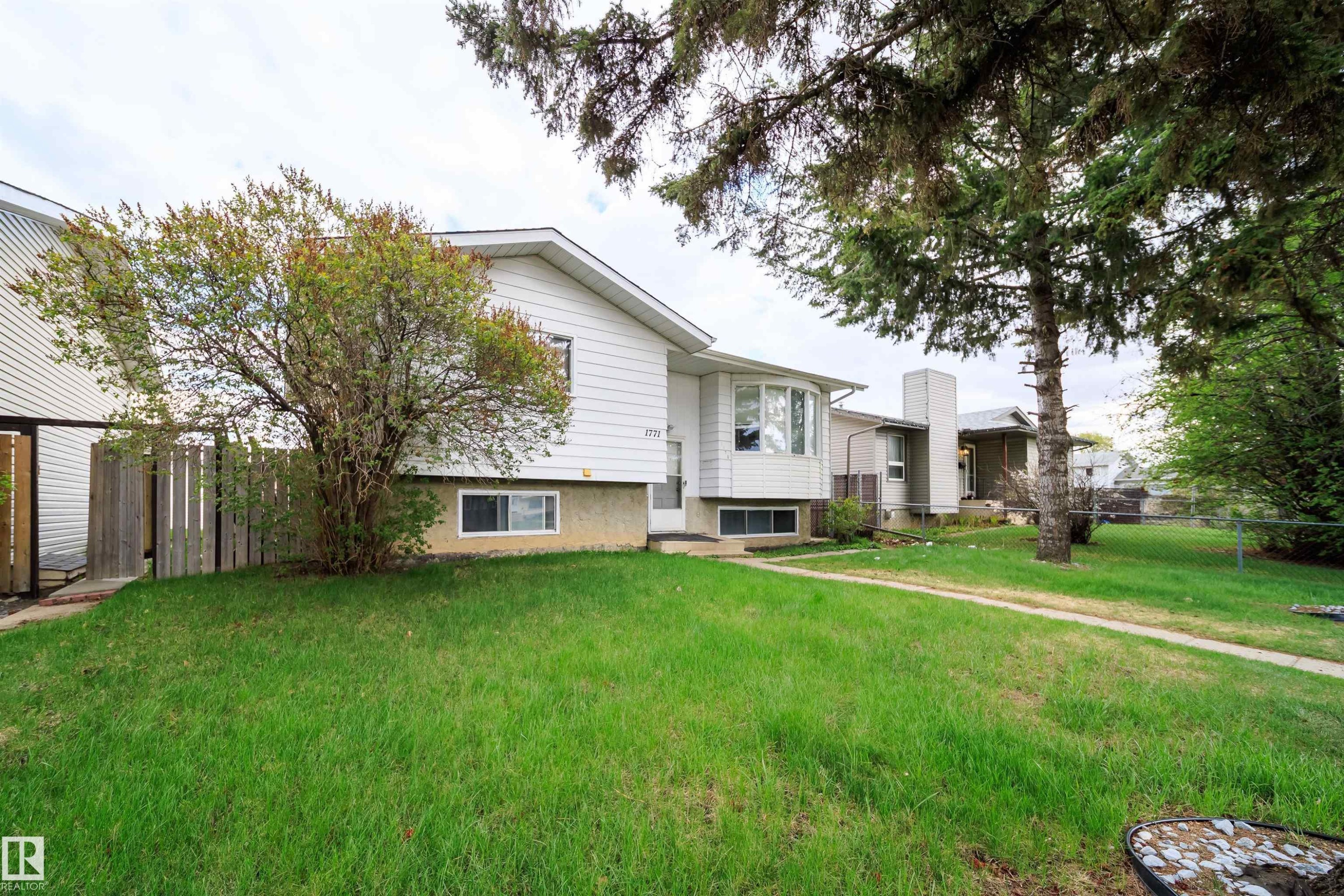 Front exterior featuring white horizontal siding, a bay window, and a concrete foundation - 1771 37 Street, Edmonton, AB - Outdoor