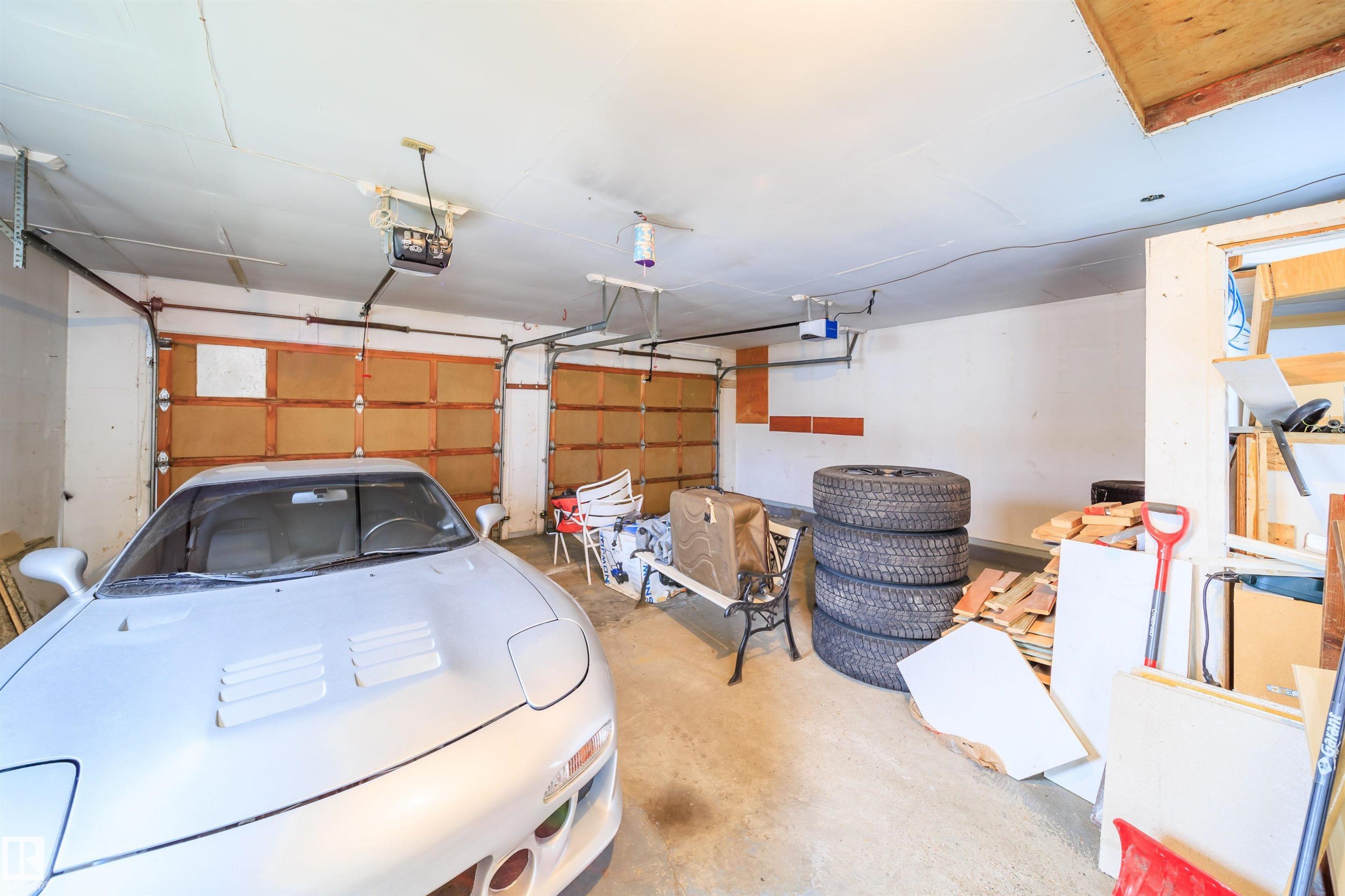Attached two-car garage featuring segmented wooden doors and overhead openers - 1771 37 Street, Edmonton, AB - Indoor Photo Showing Garage