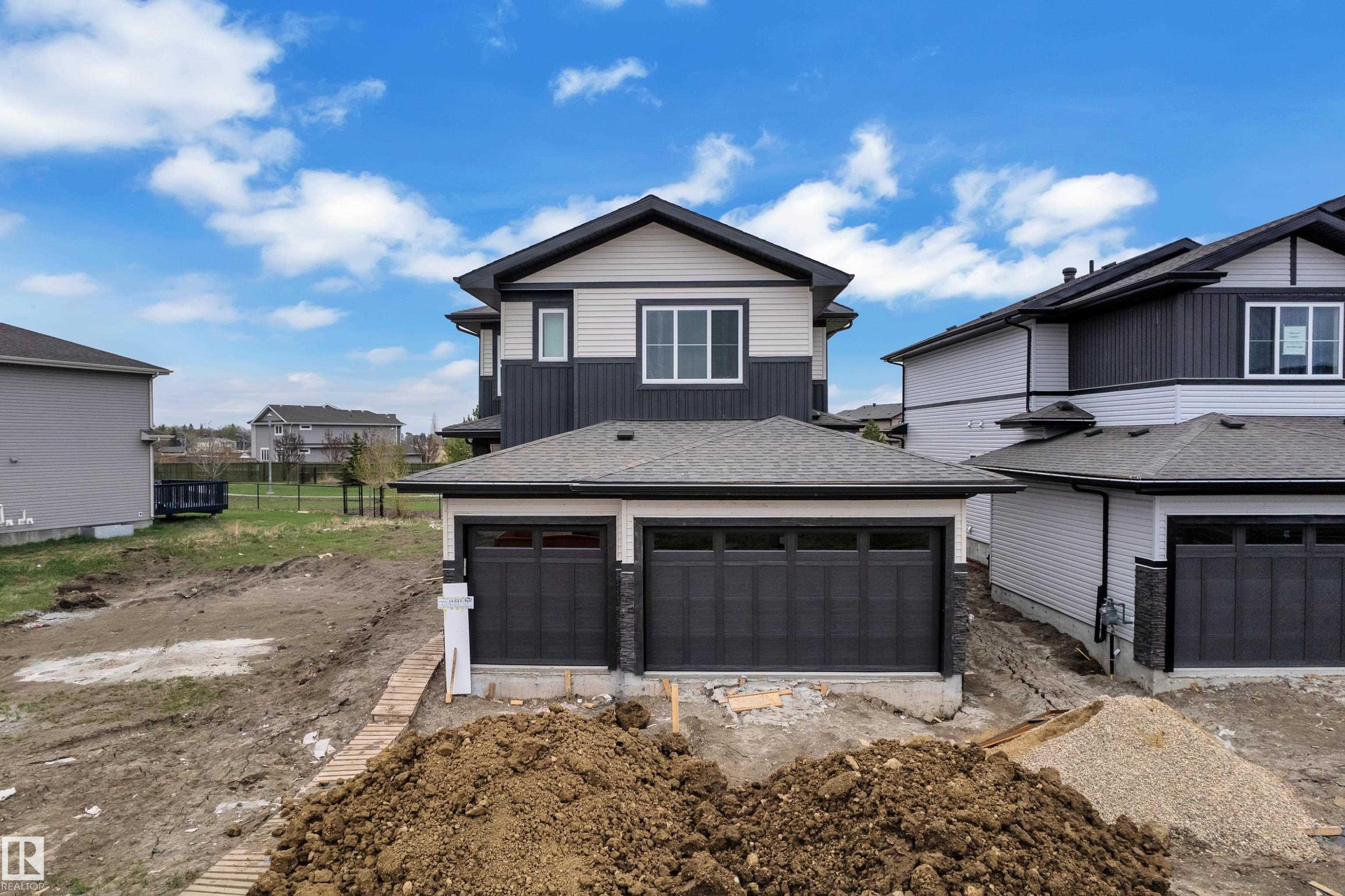Contemporary exterior featuring a two-tone facade with dark siding and light-colored panels - 12623 44 Street, Edmonton, AB