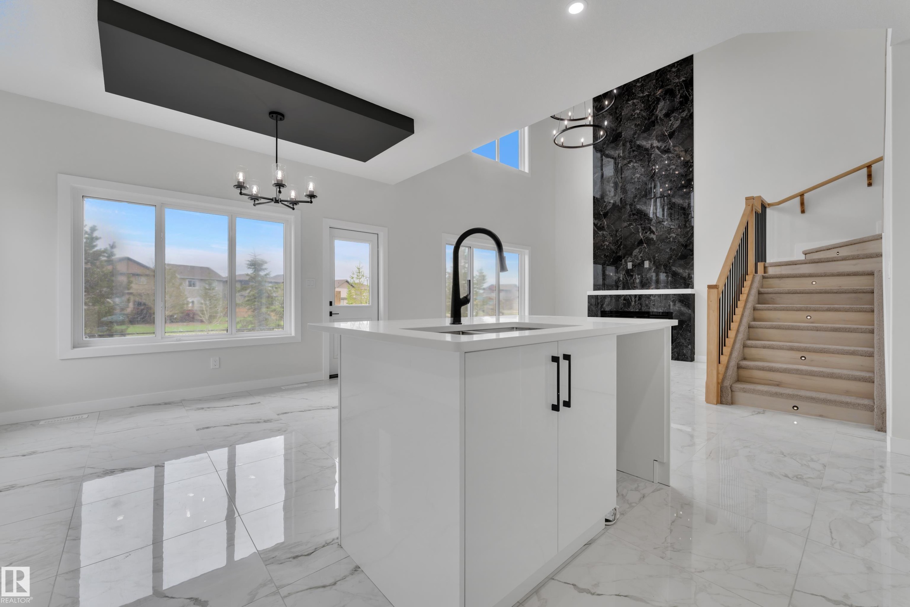 Central white kitchen island with a matte black faucet and cabinet hardware - 12623 44 Street, Edmonton, AB