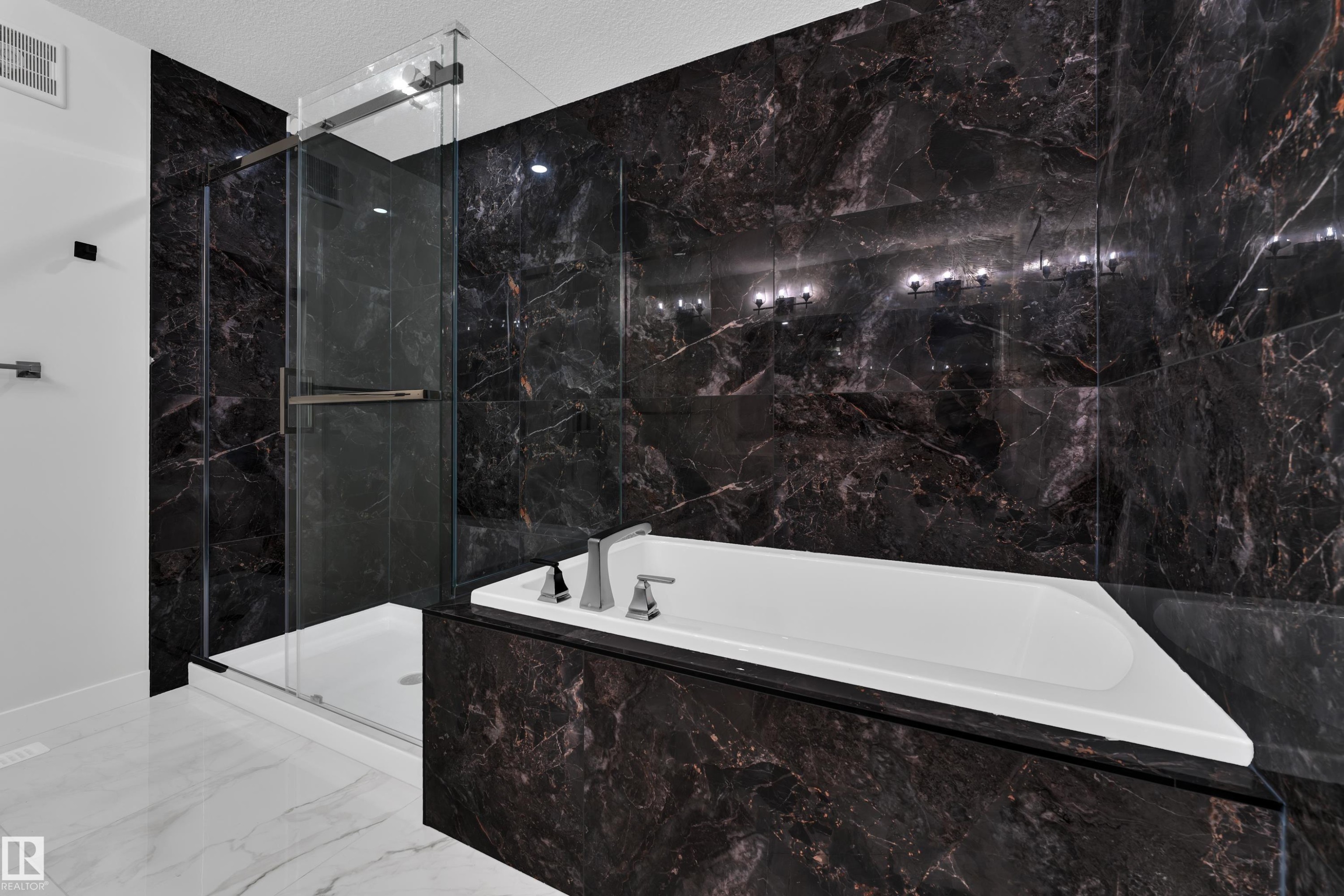 Deep-toned marble-look wall tiling surrounds the built-in bathtub and glass-enclosed shower - 12623 44 Street, Edmonton, AB