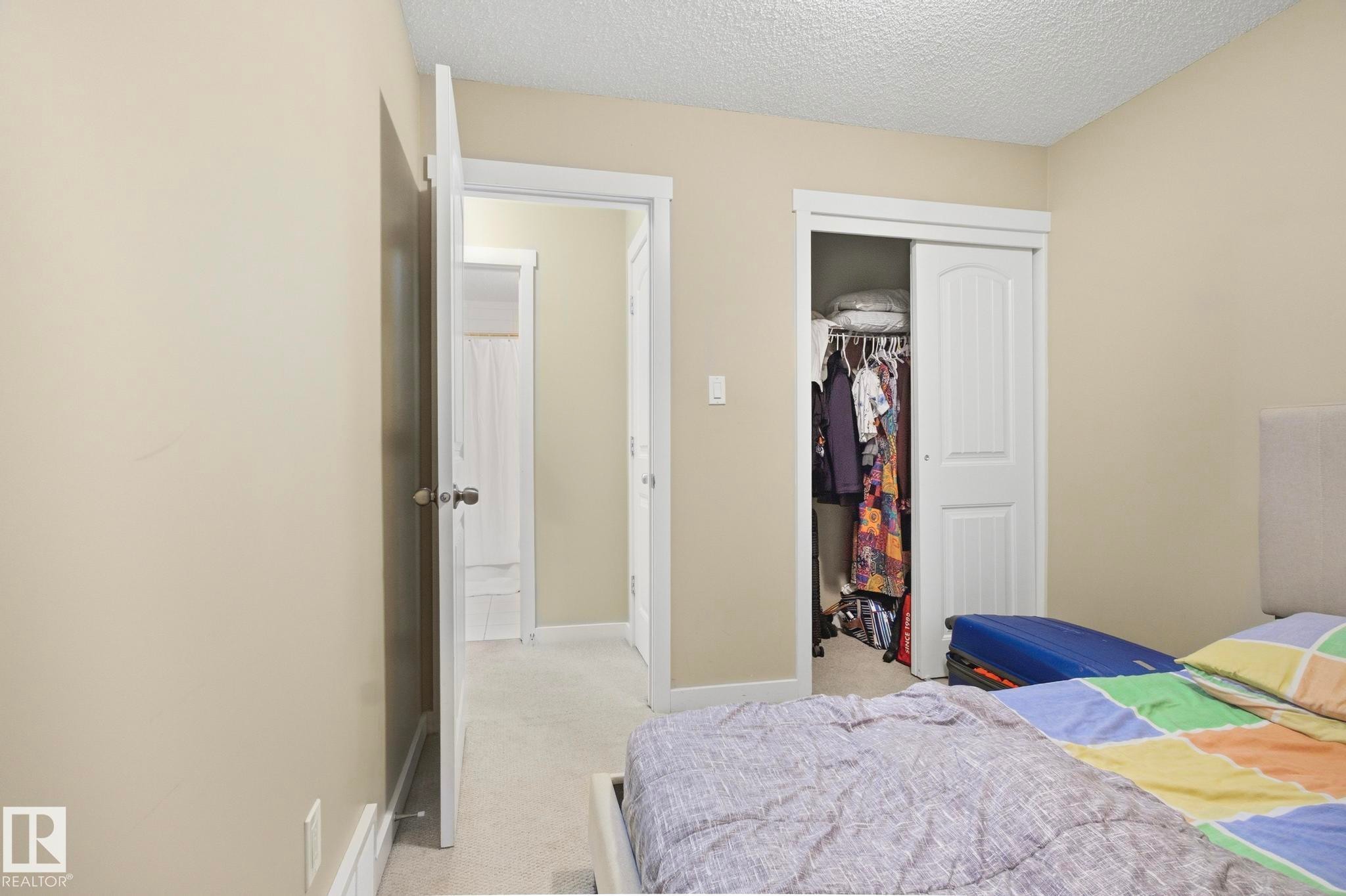 Interior room featuring neutral wall paint, white trim, and a textured ceiling - 30 6075 Schonsee Way, Edmonton, AB - Indoor Photo Showing Bedroom
