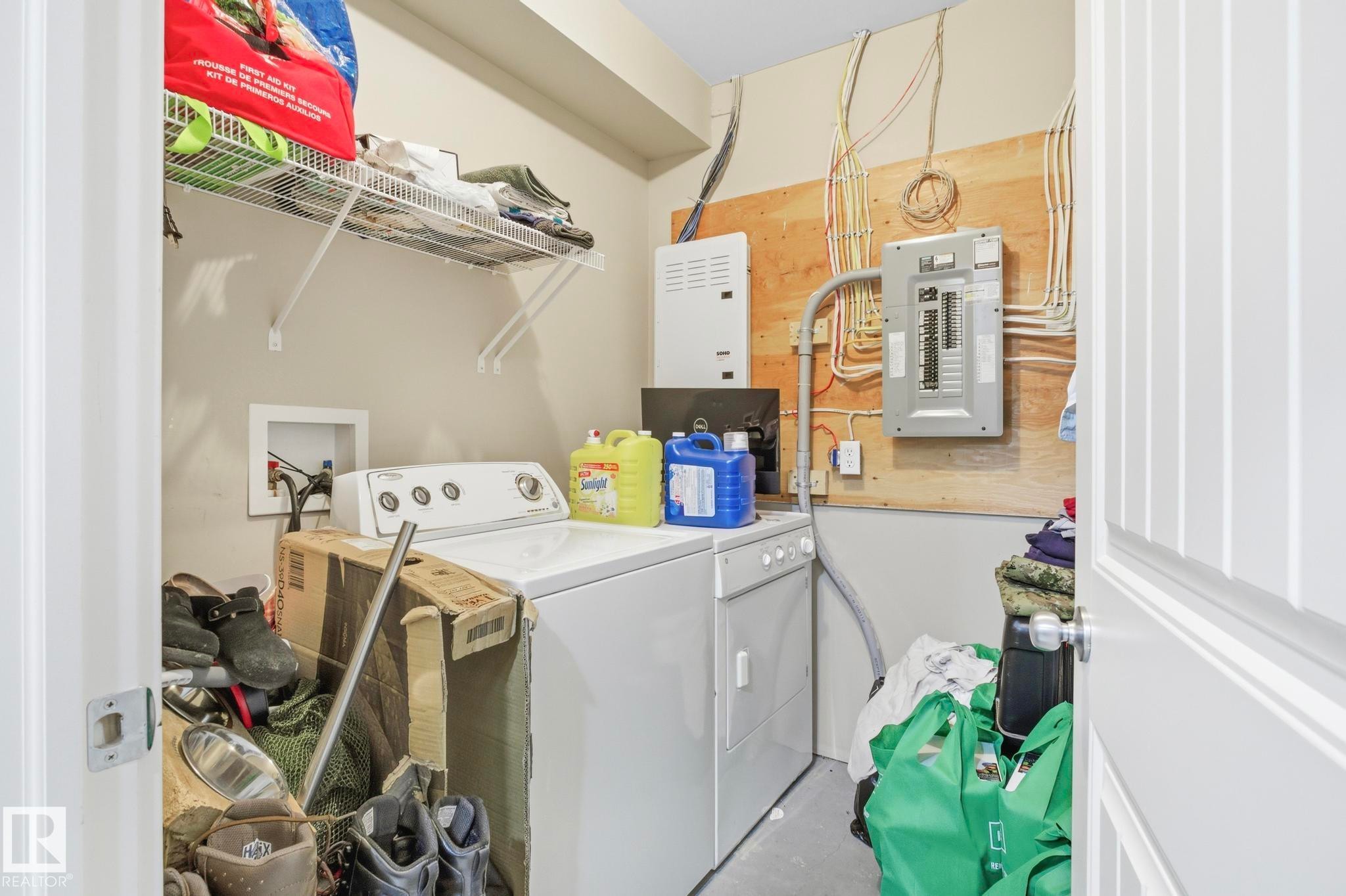 Dedicated utility space featuring washer and dryer hookups, wire shelving, and visible electrical panels - 30 6075 Schonsee Way, Edmonton, AB - Indoor Photo Showing Laundry Room