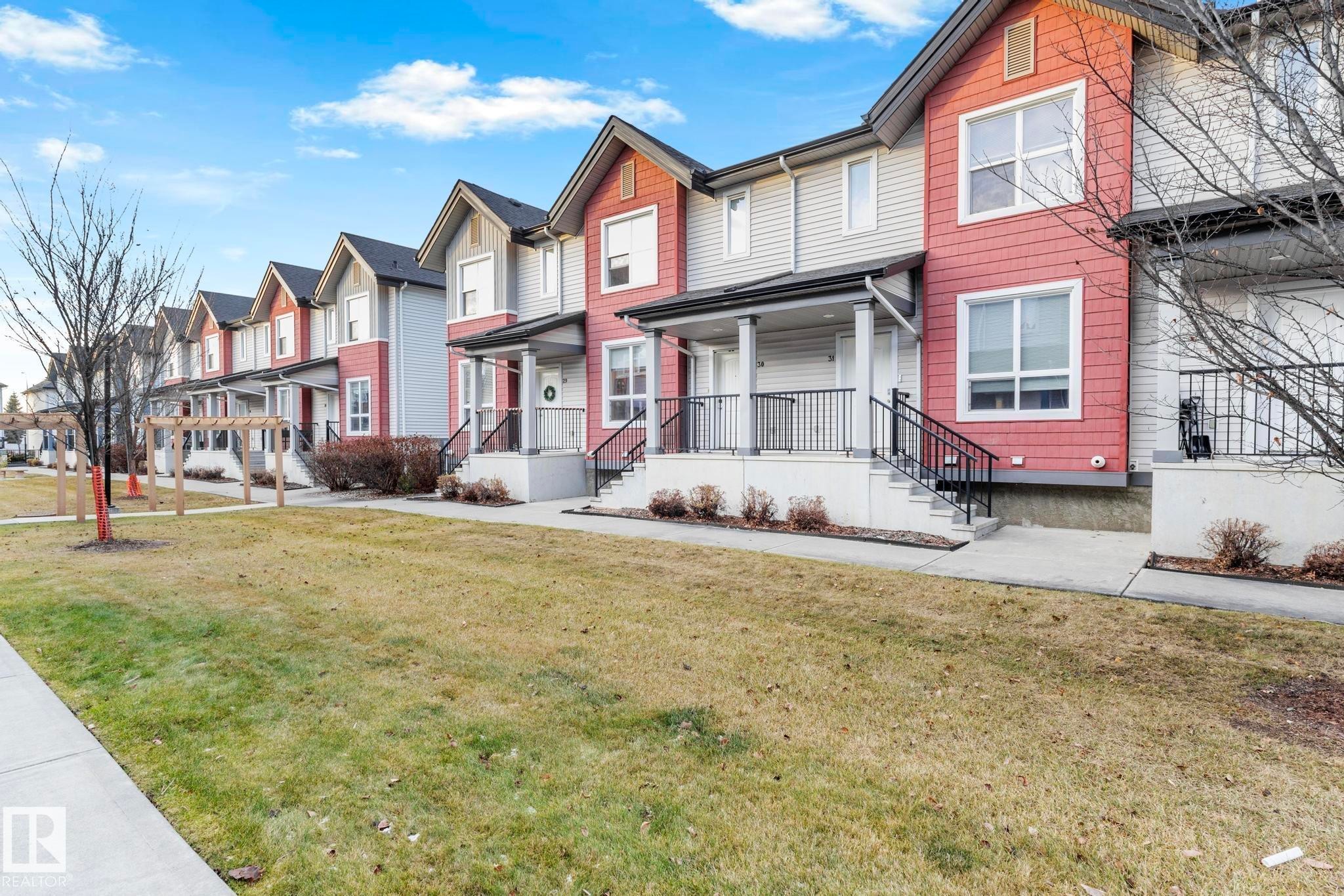 Exterior featuring multi-toned siding, gabled rooflines, and covered front entrances - 30 6075 Schonsee Way, Edmonton, AB - Outdoor With Deck Patio Veranda With Facade
