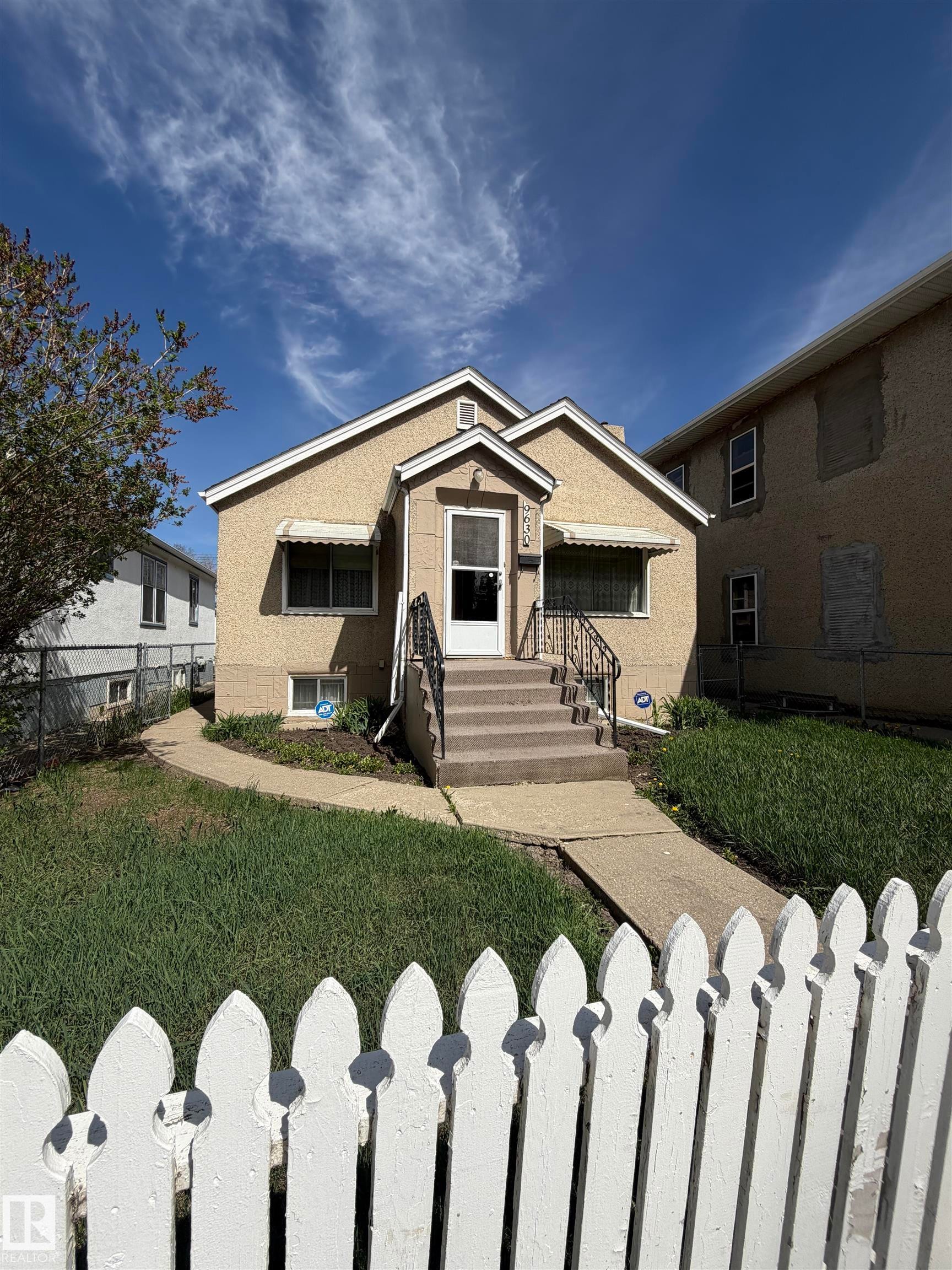 Stucco exterior with a peaked roofline and prominent front entryway - 9630 106 Avenue, Edmonton, AB - Outdoor